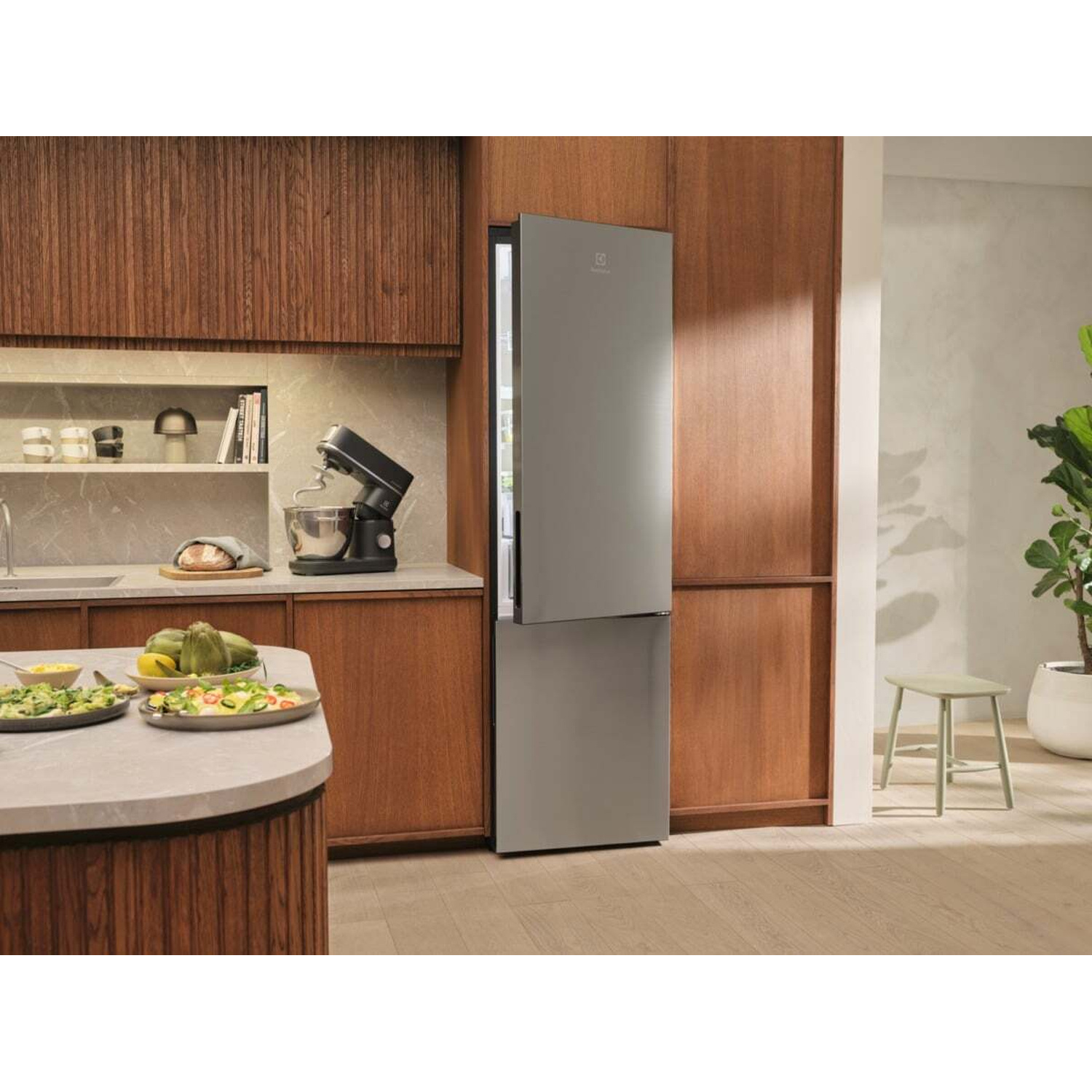 Una cucina moderna con frigorifero grigio, mobili in legno e cibo sul bancone.