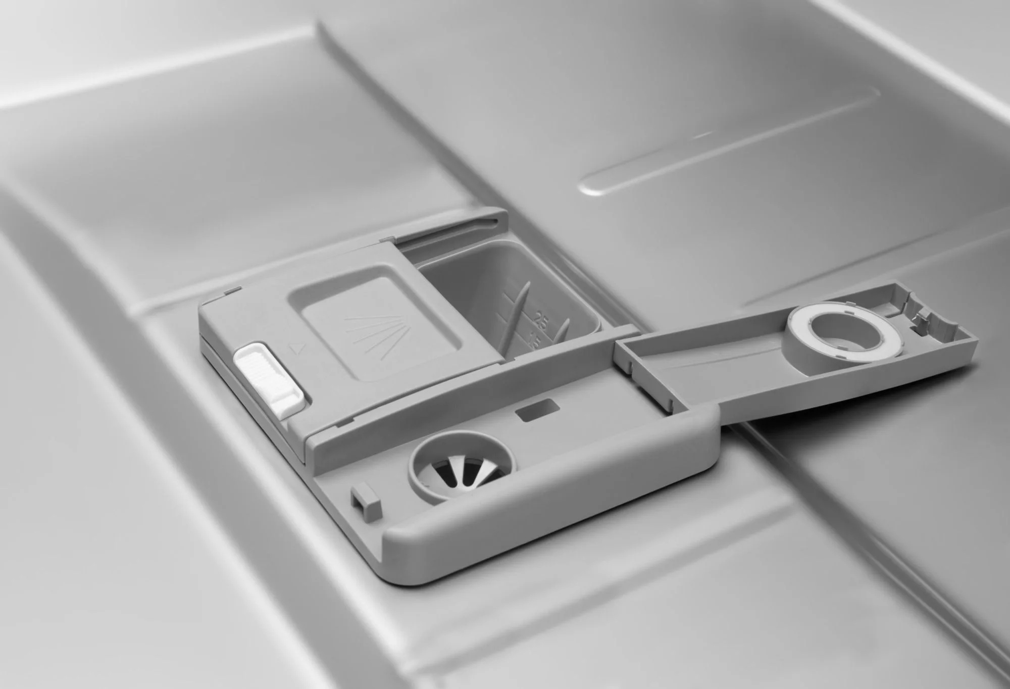 Szary dozownik detergentu do zmywarki z klapką i podziałką.