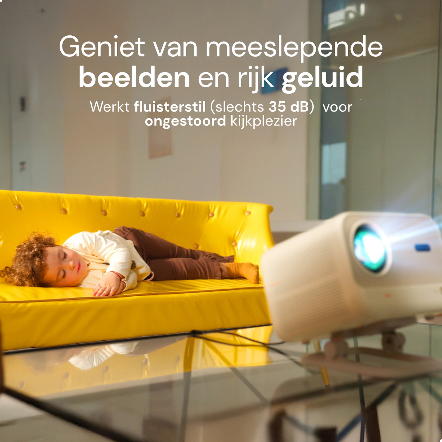 Kind slaapt op gele bank bij projector. Tekst: Geniet van meeslepende beelden.