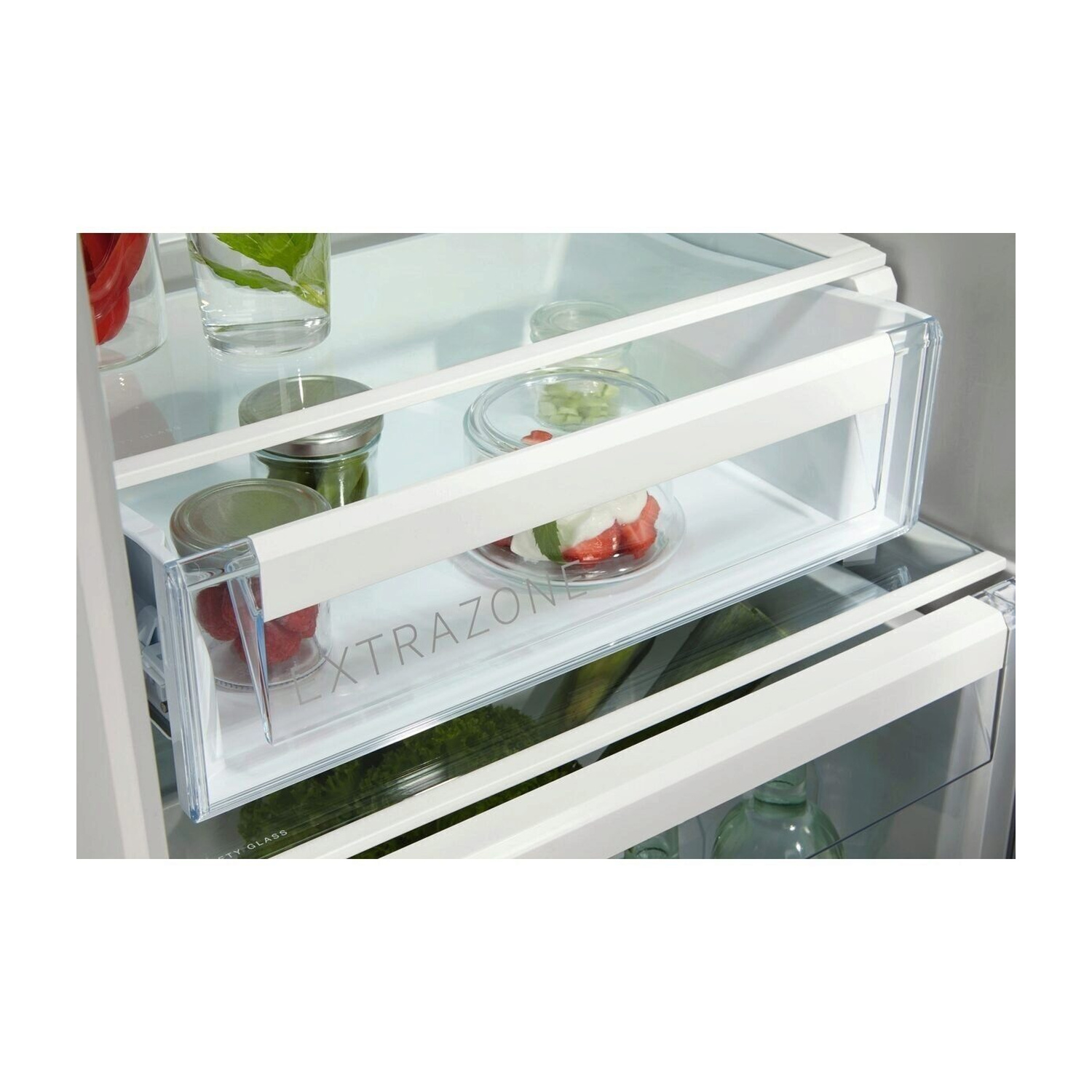 Un compartimento del frigorifero con un cassetto pieno di frutta e verdura.