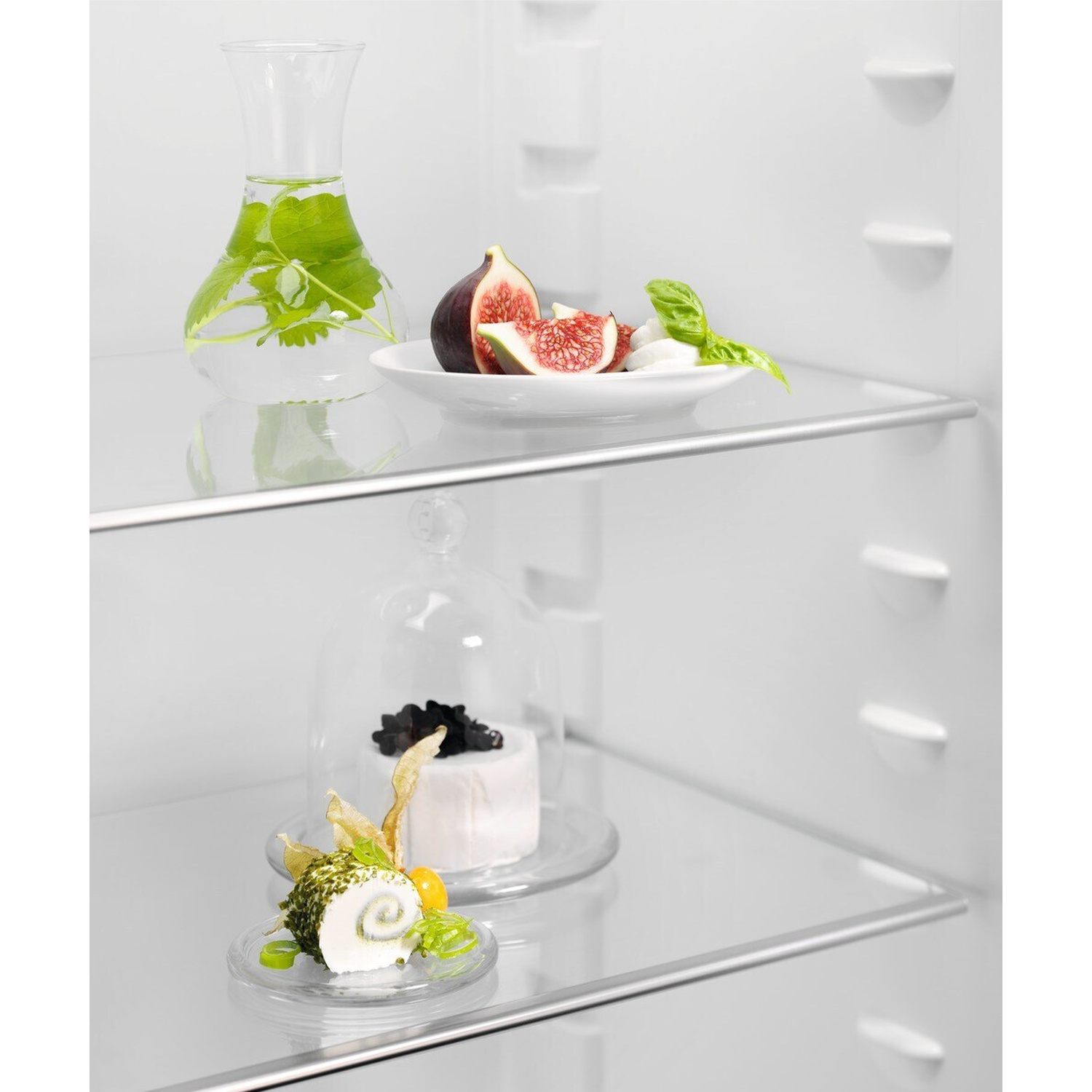 Una brocca d'acqua con menta, fichi e mozzarella su uno scaffale.