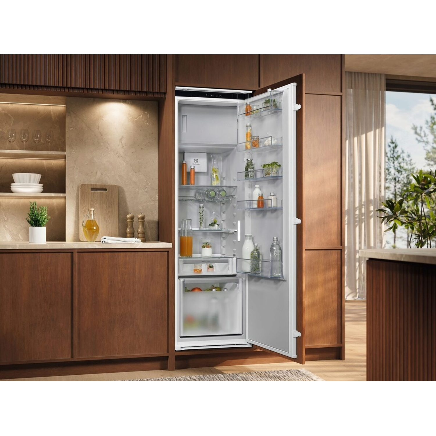 Un frigorifero aperto in una cucina moderna con armadi in legno e vista finestra.