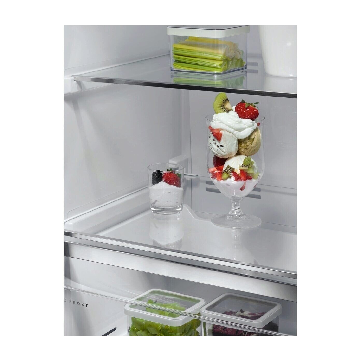 Coppetta gelato con panna, frutta e bacche, accanto a un bicchiere di yogurt e bacche.