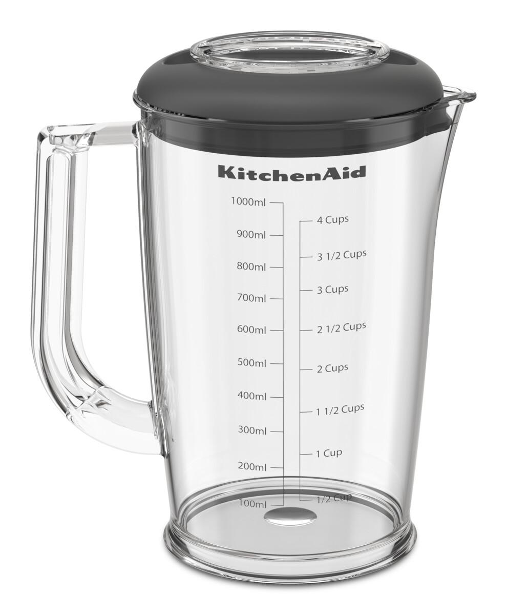 Ein klarer KitchenAid-Mixerbehälter mit schwarzem Deckel und Messmarkierungen in ml und Tassen.