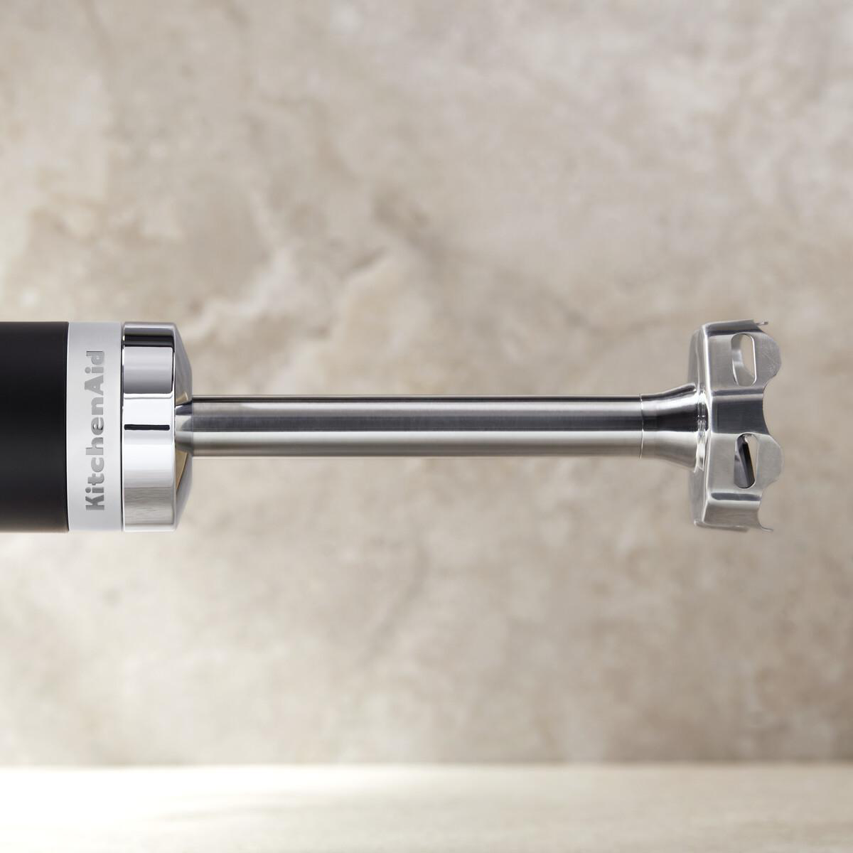 Ein schwarzer Stabmixer mit KitchenAid-Logo und Metallaufsatz auf hellem Untergrund.