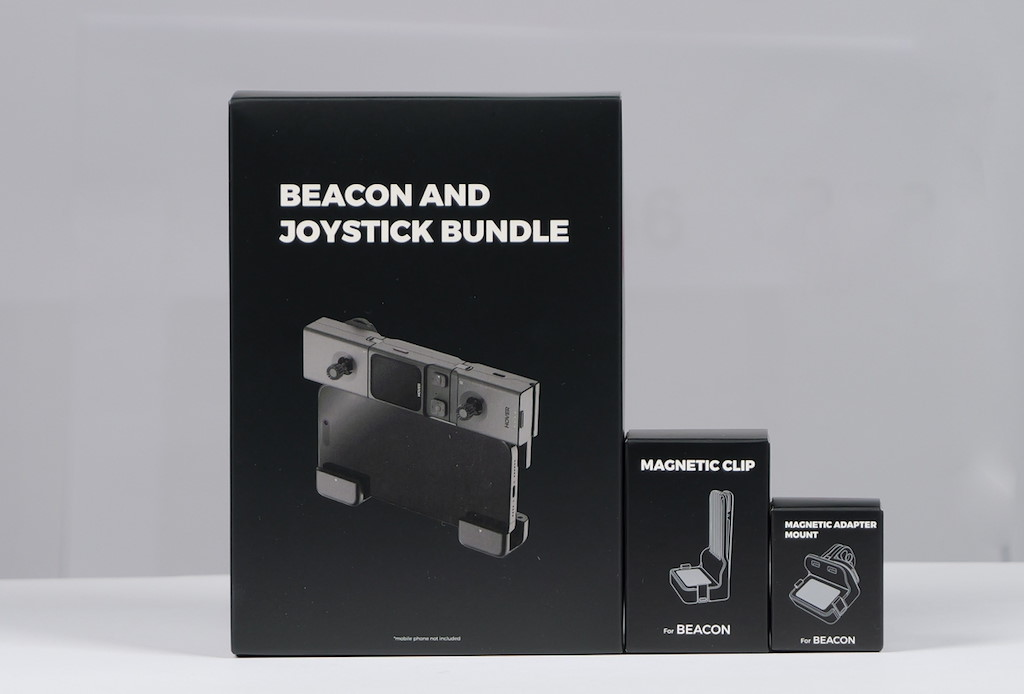 Drei schwarze Verpackungen: eine große für ein Beacon- und Joystick-Bundle, eine mittlere für einen Magnetclip, eine kleine für eine magnetische Halterung.