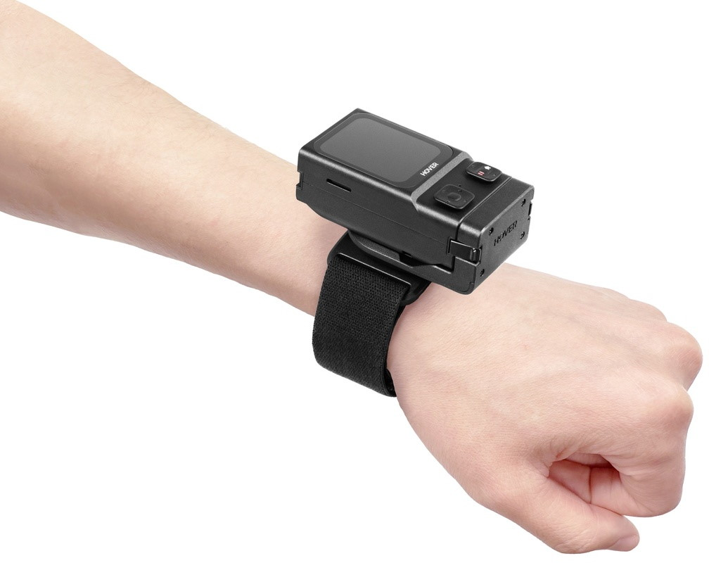 Ein schwarzer Scanner ist mit einem Gurt am Arm befestigt.
