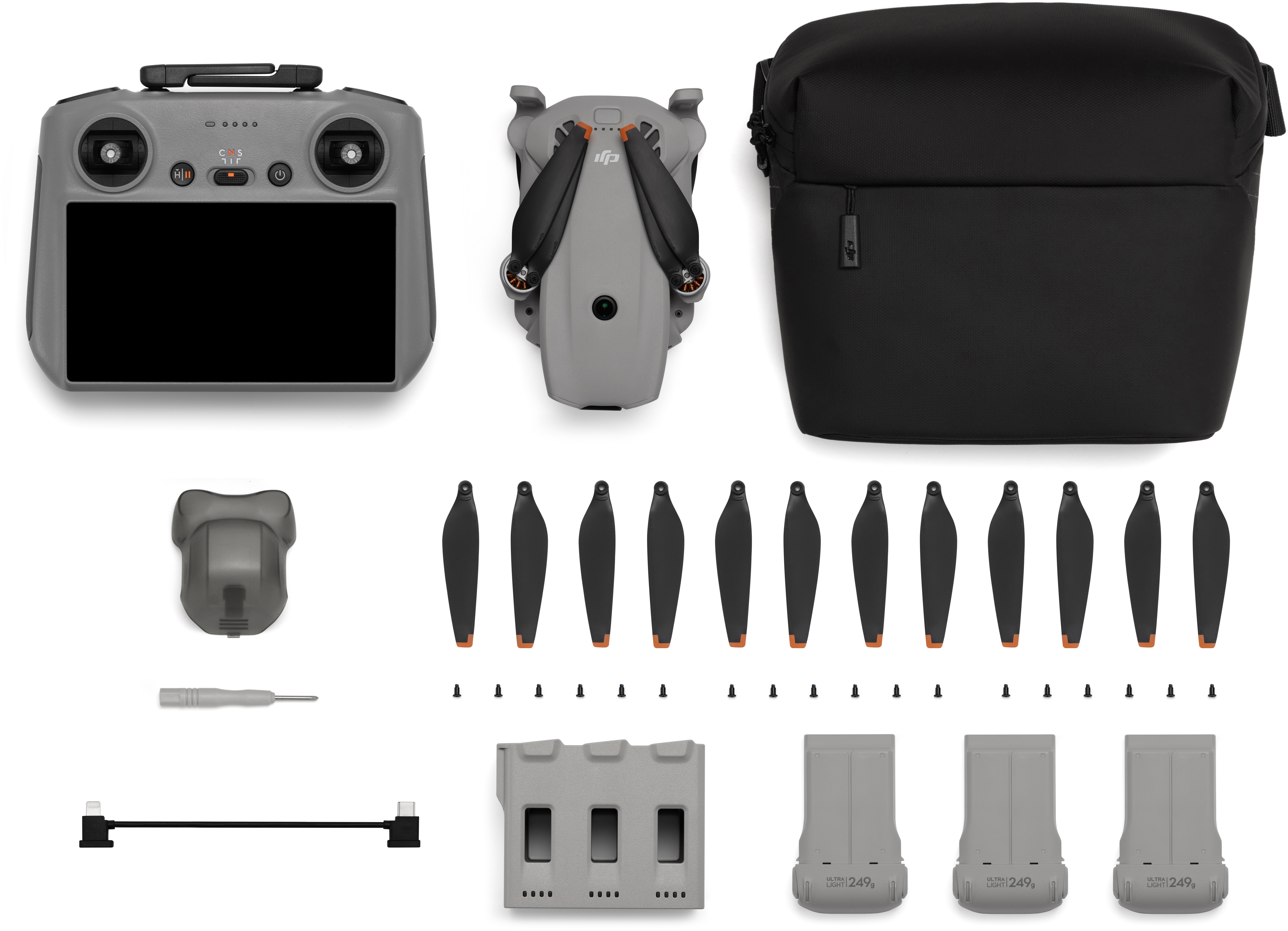 Controller drone grigio, drone, borsa nera, eliche di ricambio, batterie, cacciavite.