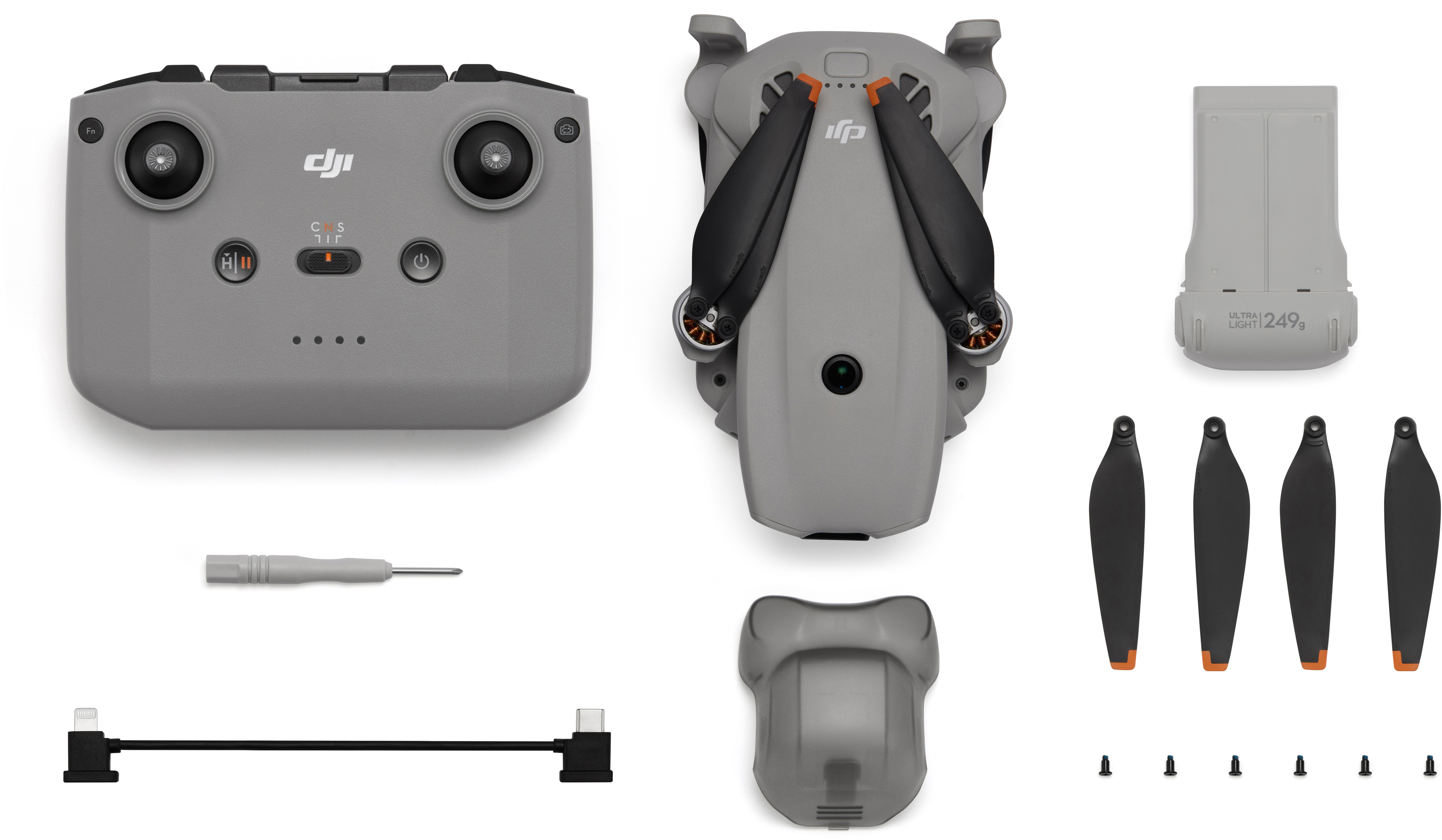 Grauer Drohnen-Controller, Drohne, Akku, Propeller, Schraubendreher, Kabel und Schrauben.