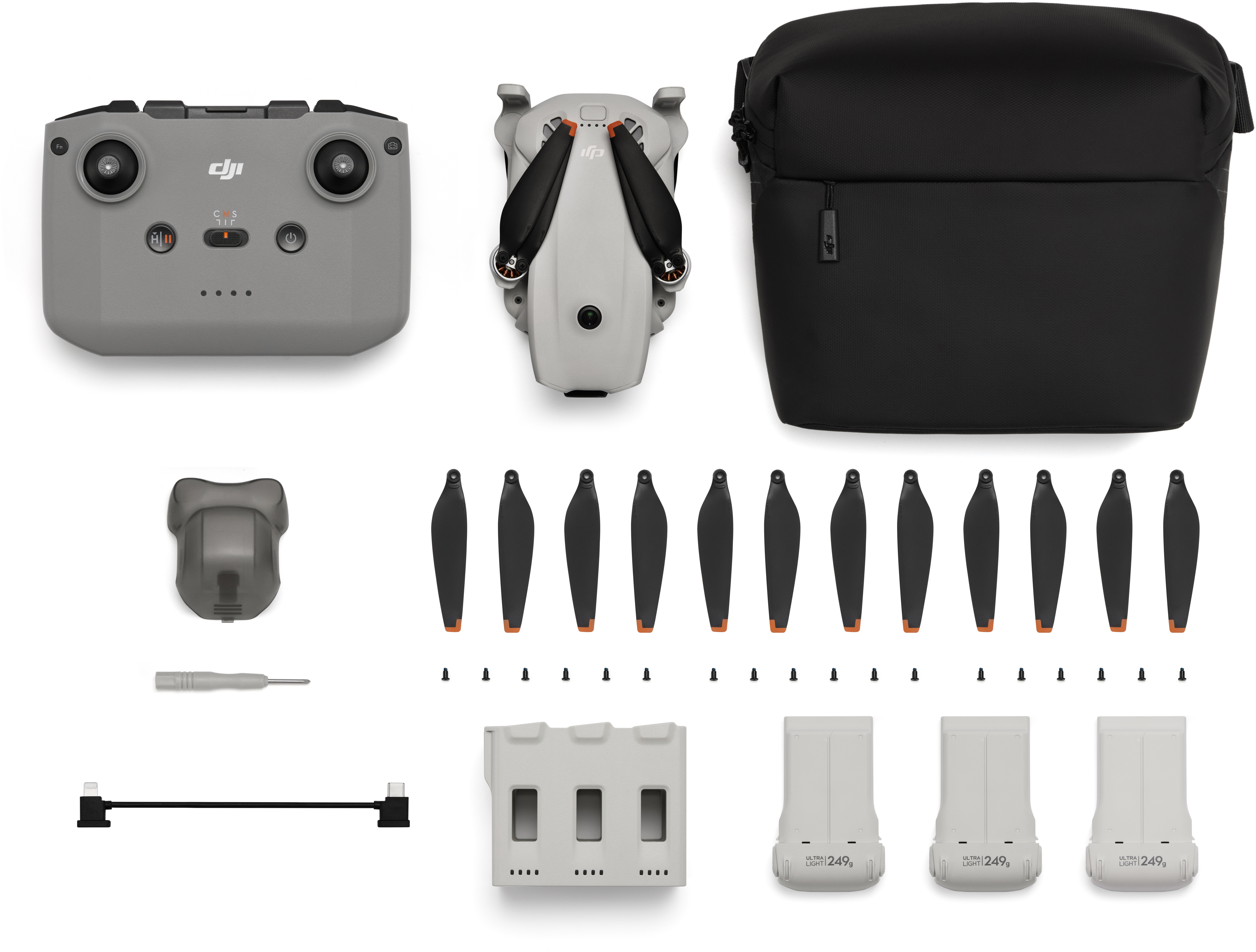 Drone, telecomando, borsa, eliche, batterie e accessori su sfondo bianco.