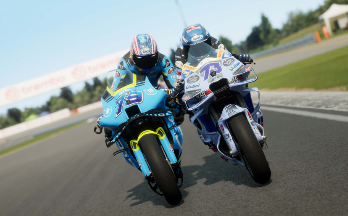 Dos pilotos de moto en una pista, con motos azules y blancas en primer plano.