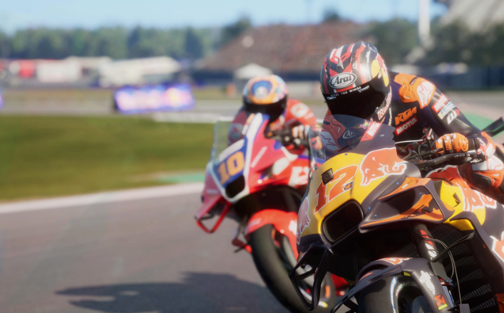 Dos corredores de motos en una pista, uno lleva el número 12.
