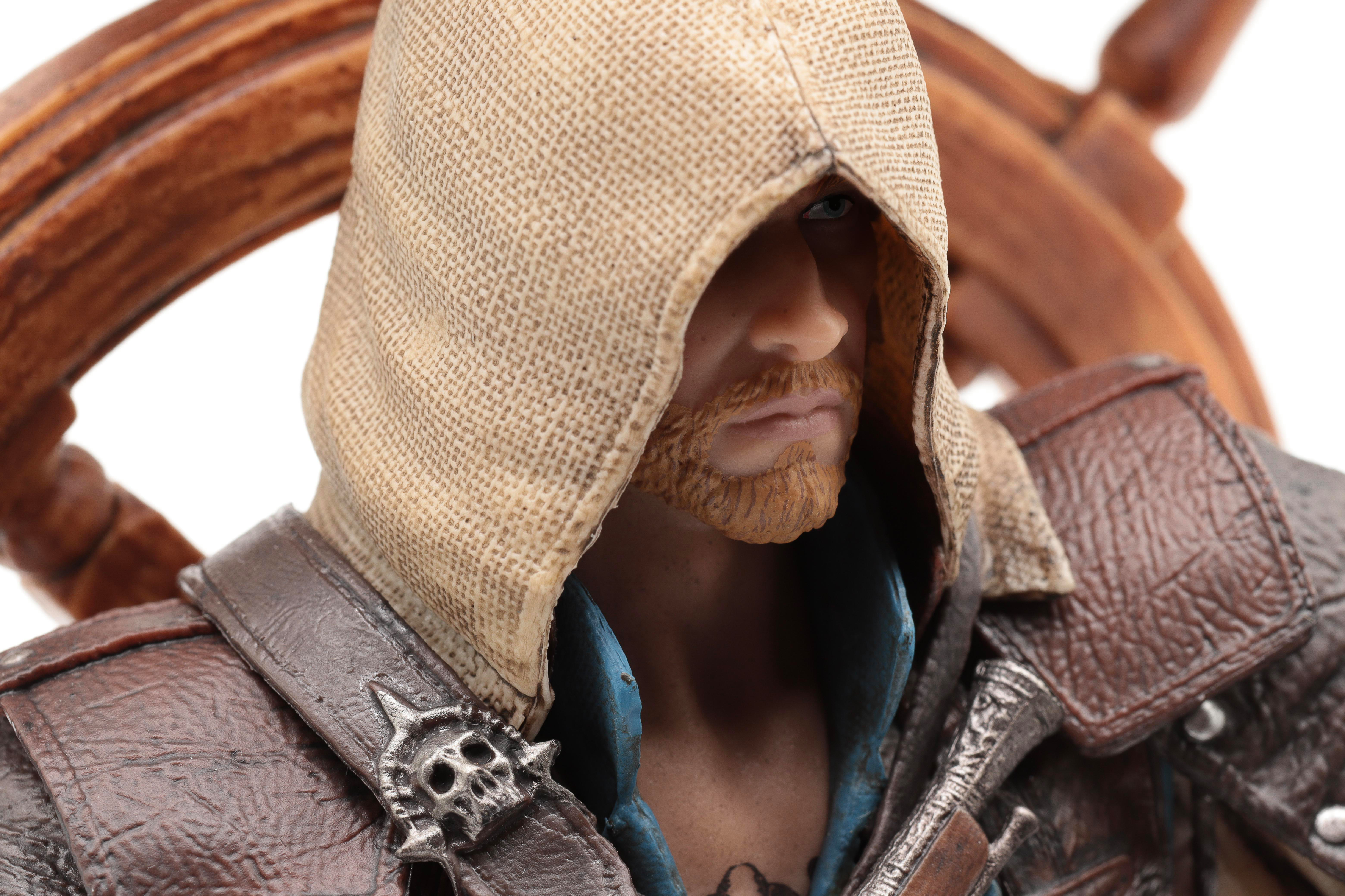 Eine Figur mit Kapuze, brauner Kleidung und einem Totenkopf-Abzeichen.
