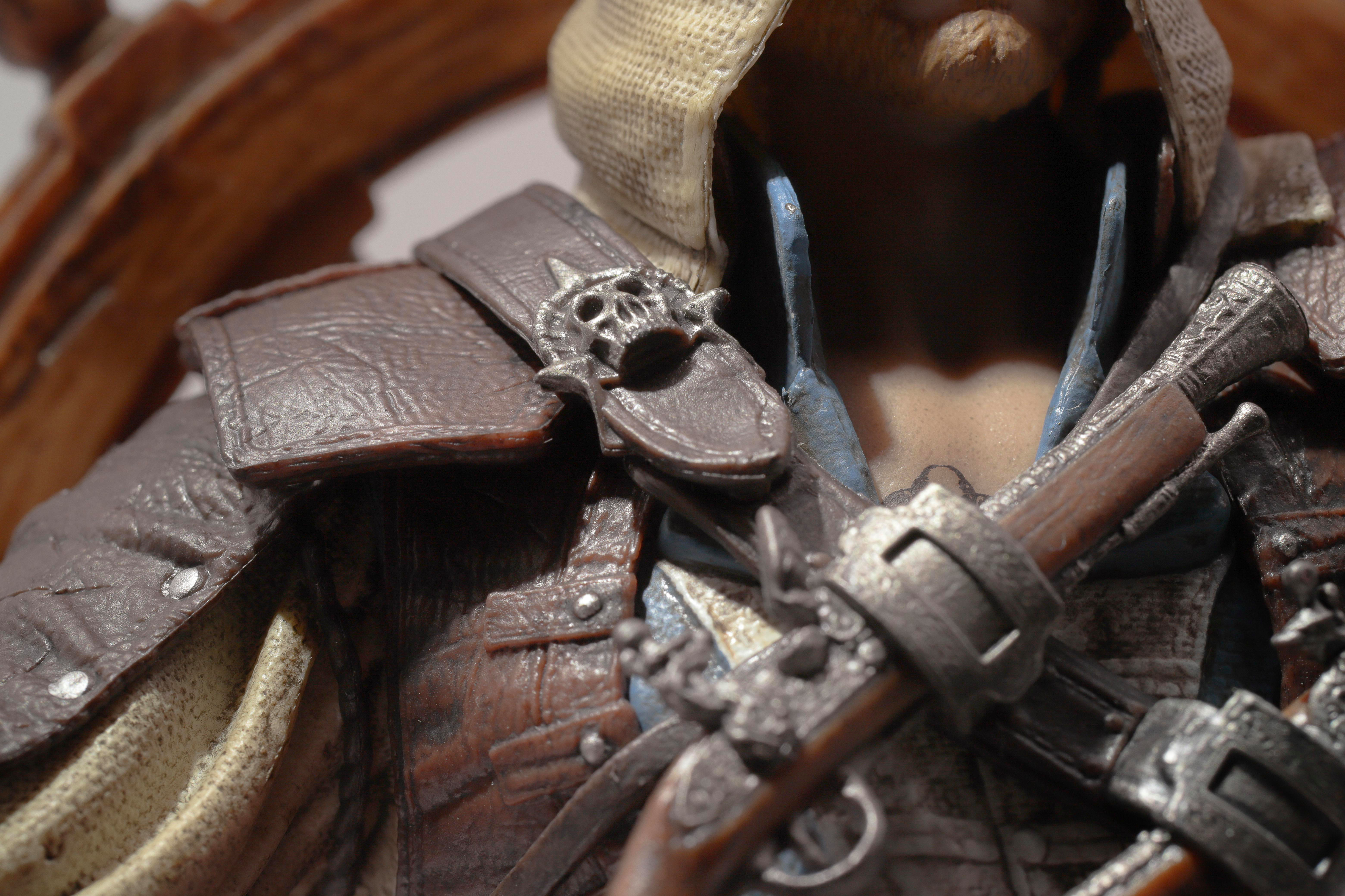 Eine Nahaufnahme einer Figur mit einem Totenkopf-Ornament an der braunen Kleidung.