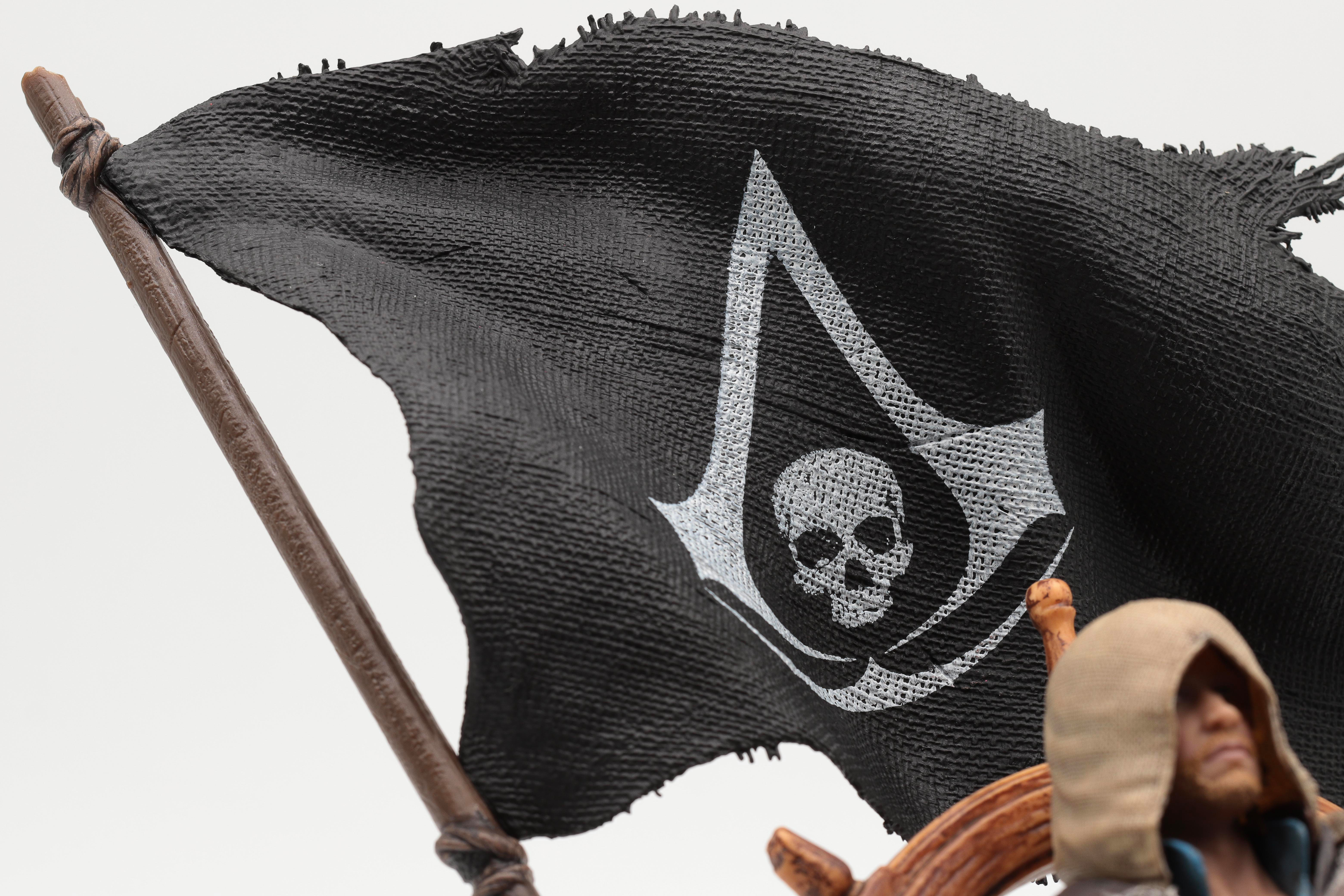 Eine schwarze Piratenflagge mit einem Totenkopf und gekreuzten Knochen weht im Wind.