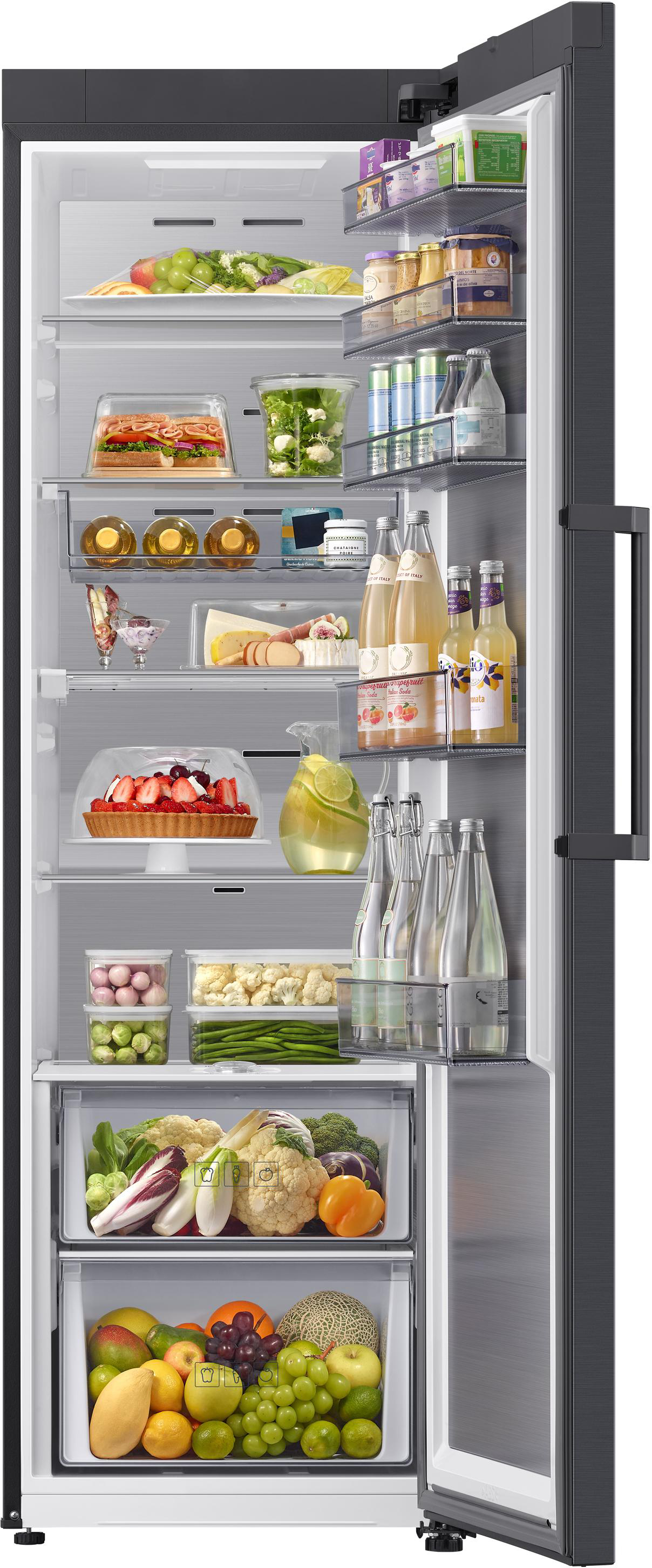 Offener Kühlschrank mit Regalen voller Lebensmittel: Obst, Gemüse, Getränke, Käse und Desserts.