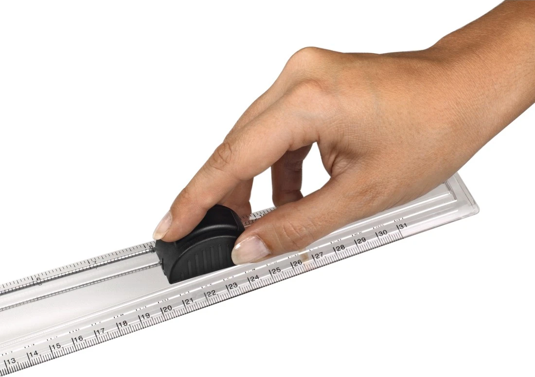 Eine Hand bedient einen schwarzen Griff auf einem transparenten Lineal mit Markierungen.