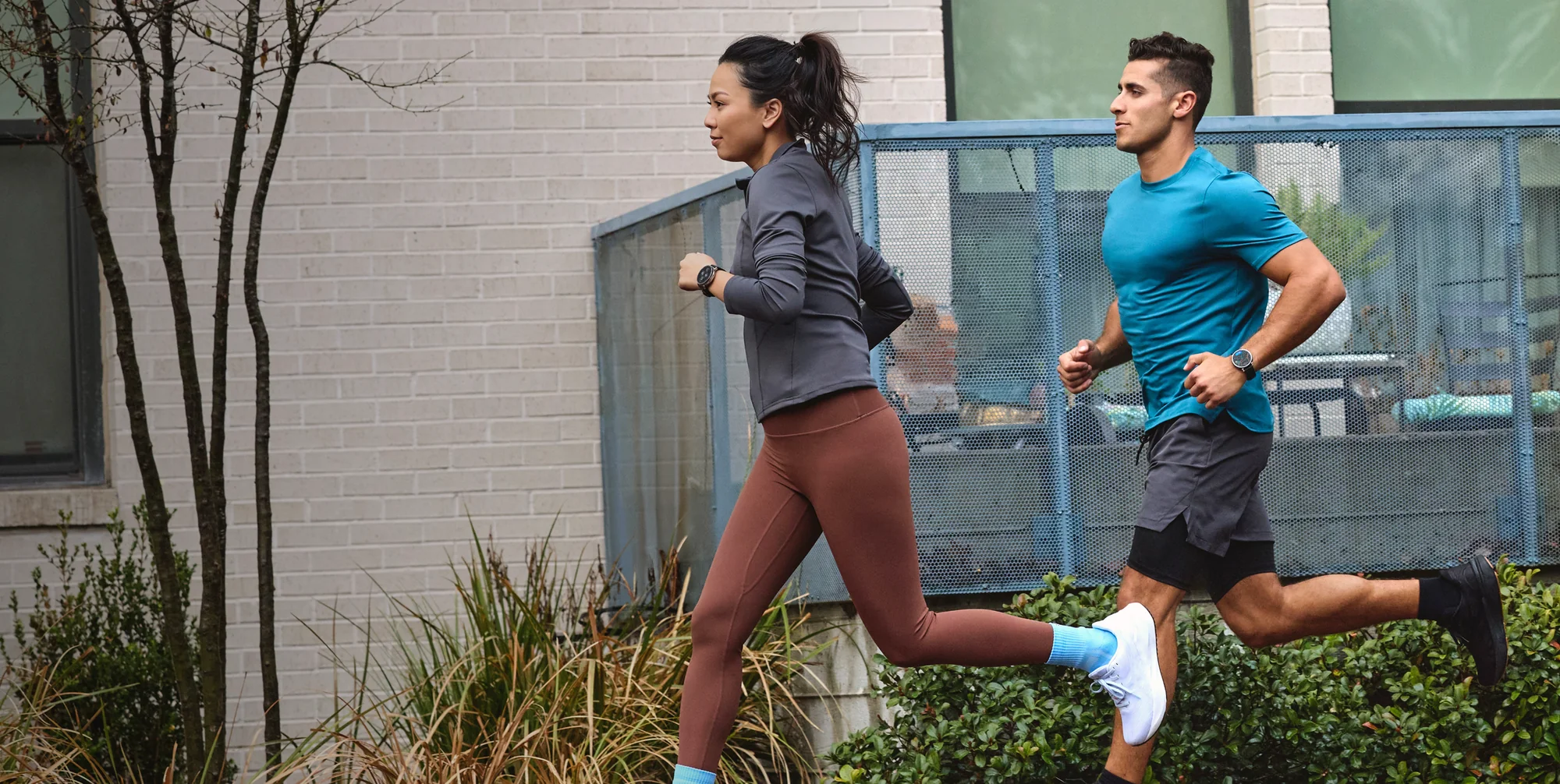 Un homme et une femme font du jogging côte à côte sur un trottoir.