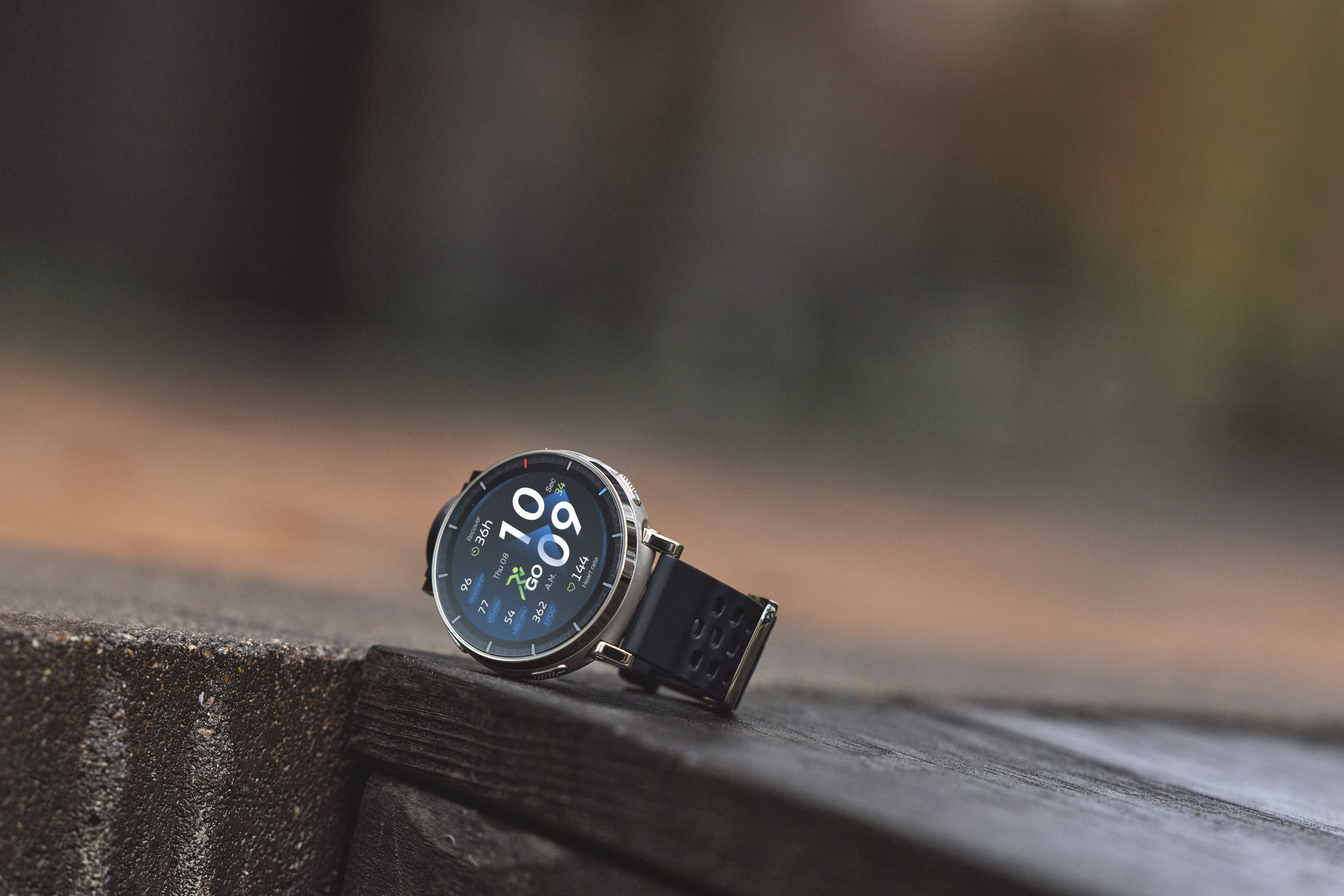 Eine digitale Smartwatch mit schwarzem Band liegt auf einem Holzuntergrund.