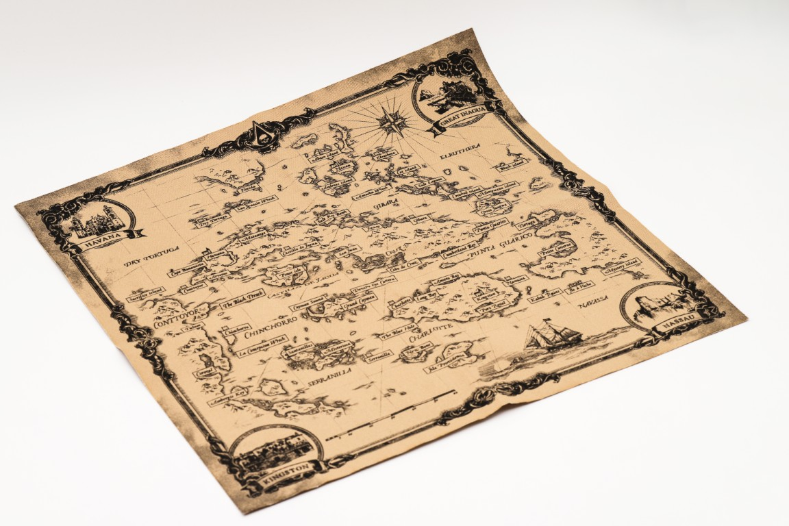 Stara mapa z wyspami, miastami i statkami, w stylu pirackim.