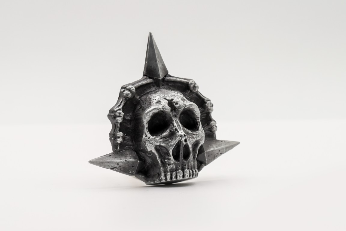 Srebrny wisiorek czaszki z gwiazdą i kośćmi.