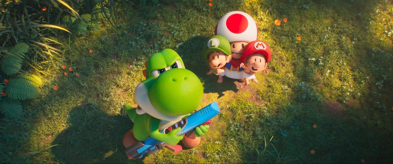 Yoshi hält eine blaue Waffe, Baby Mario, Luigi und Toad stehen im Gras.