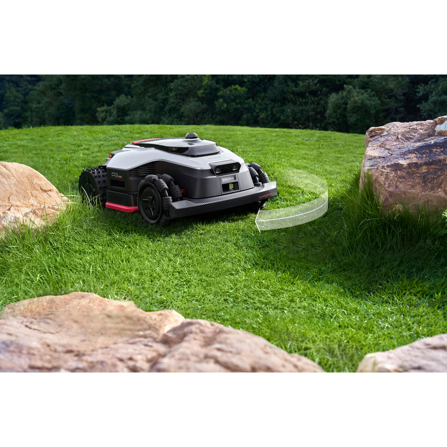 A black robot lawn mower with red accents drives on green grass.