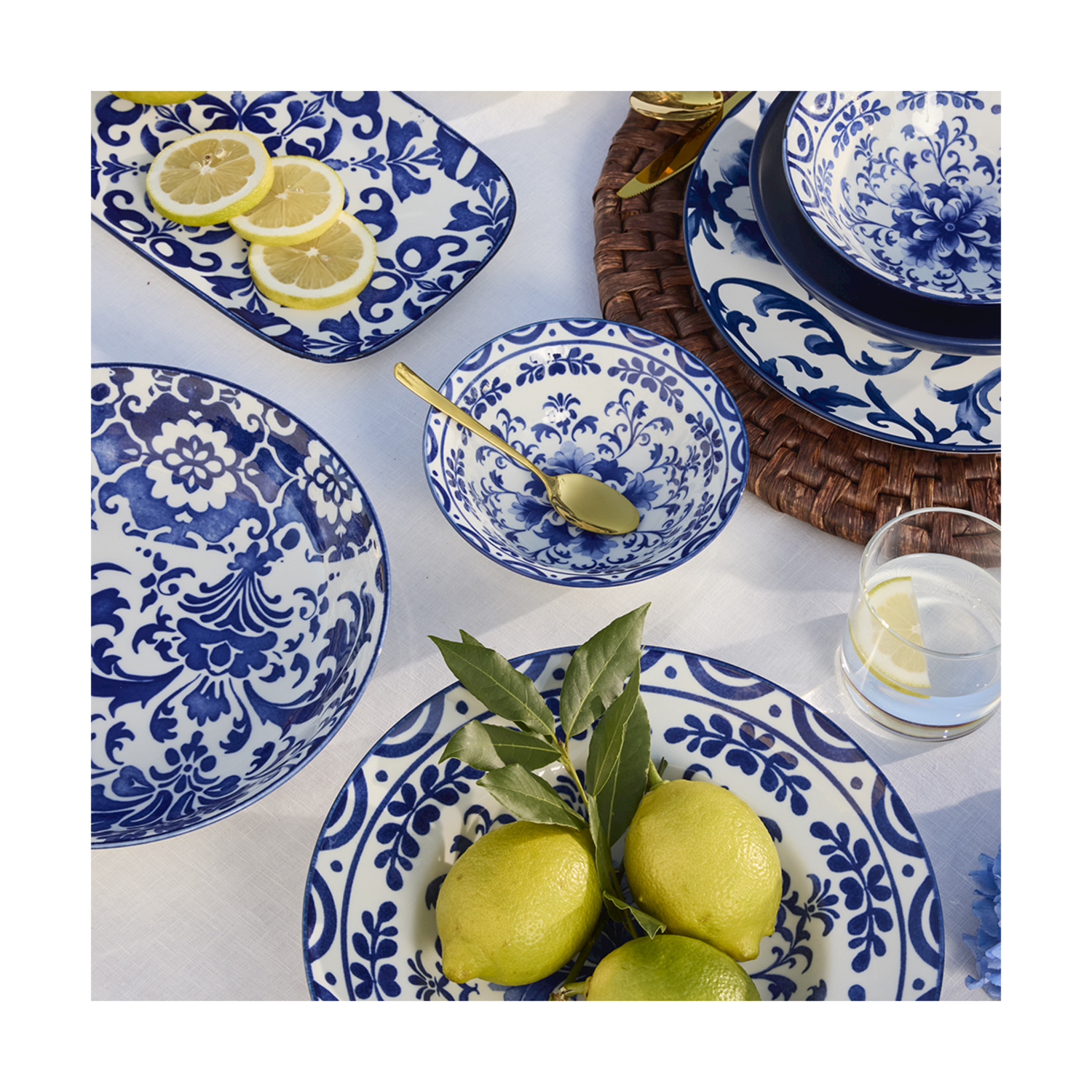 Piatti in ceramica blu e bianchi con motivi floreali, fettine di limone e limoni.