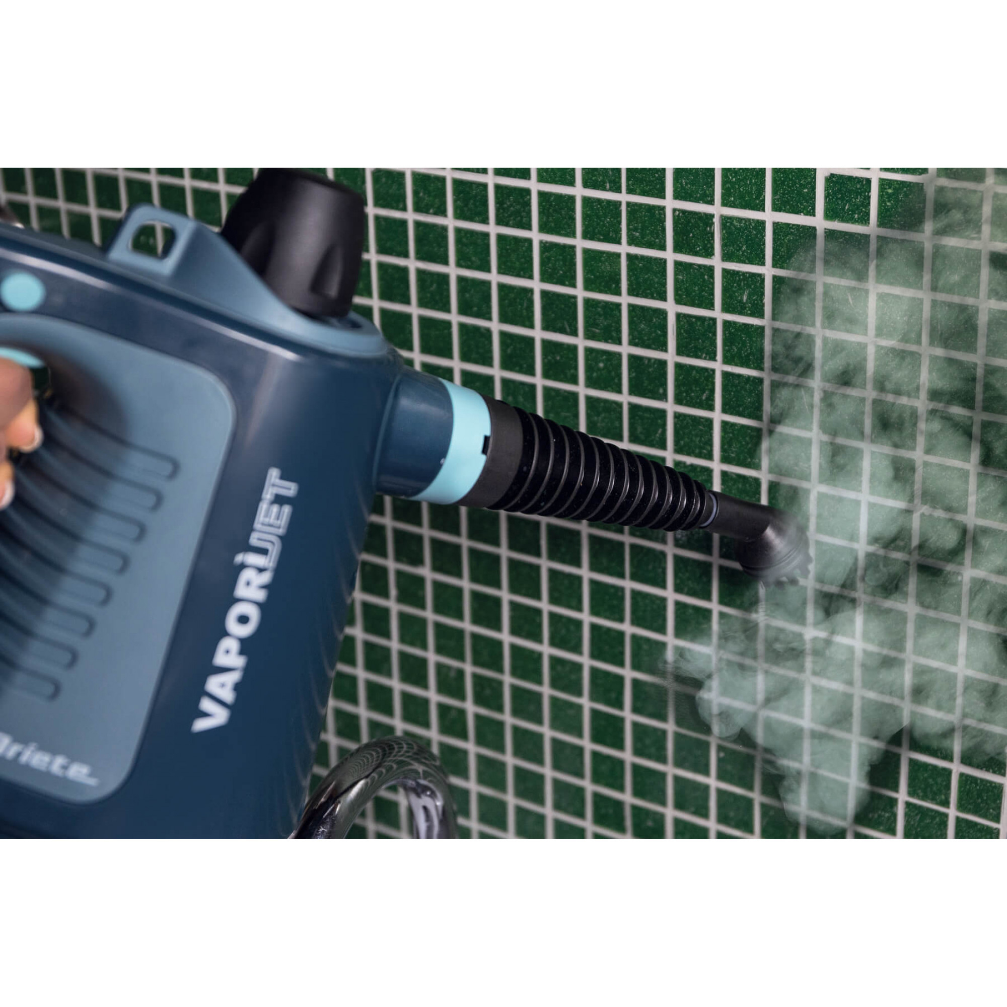 Una limpiadora a vapor azul rocía vapor sobre azulejos verdes.