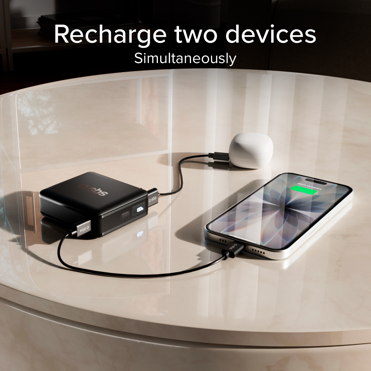 Schwarzes Powerbank lädt ein Smartphone und weiße Kopfhörer gleichzeitig auf.