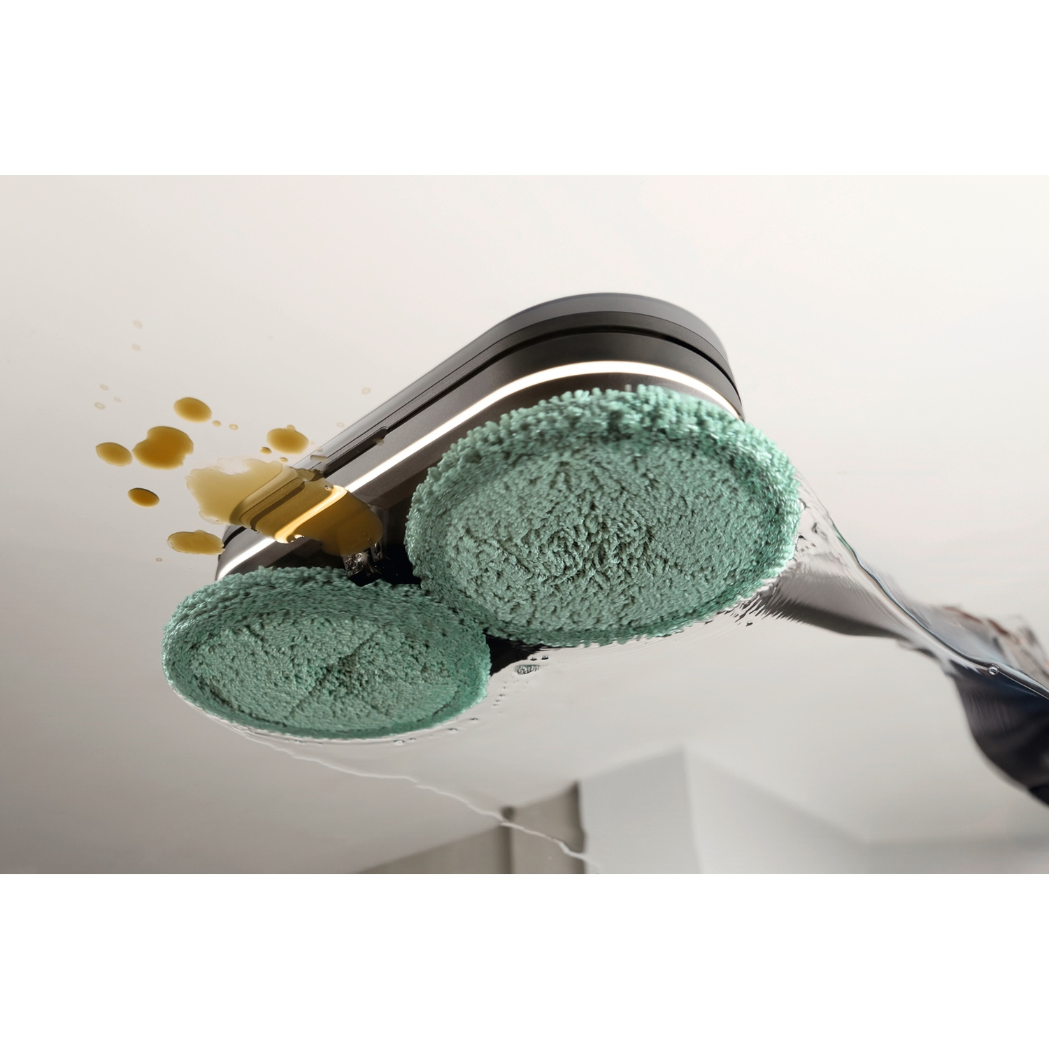 Un robot aspirateur avec des brosses vertes nettoie un déversement sur un sol clair.