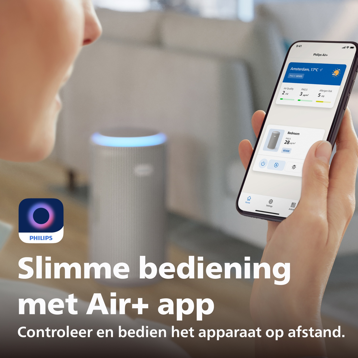 A person holds a smartphone with the Philips Air+ app. An air purifier is in the background.