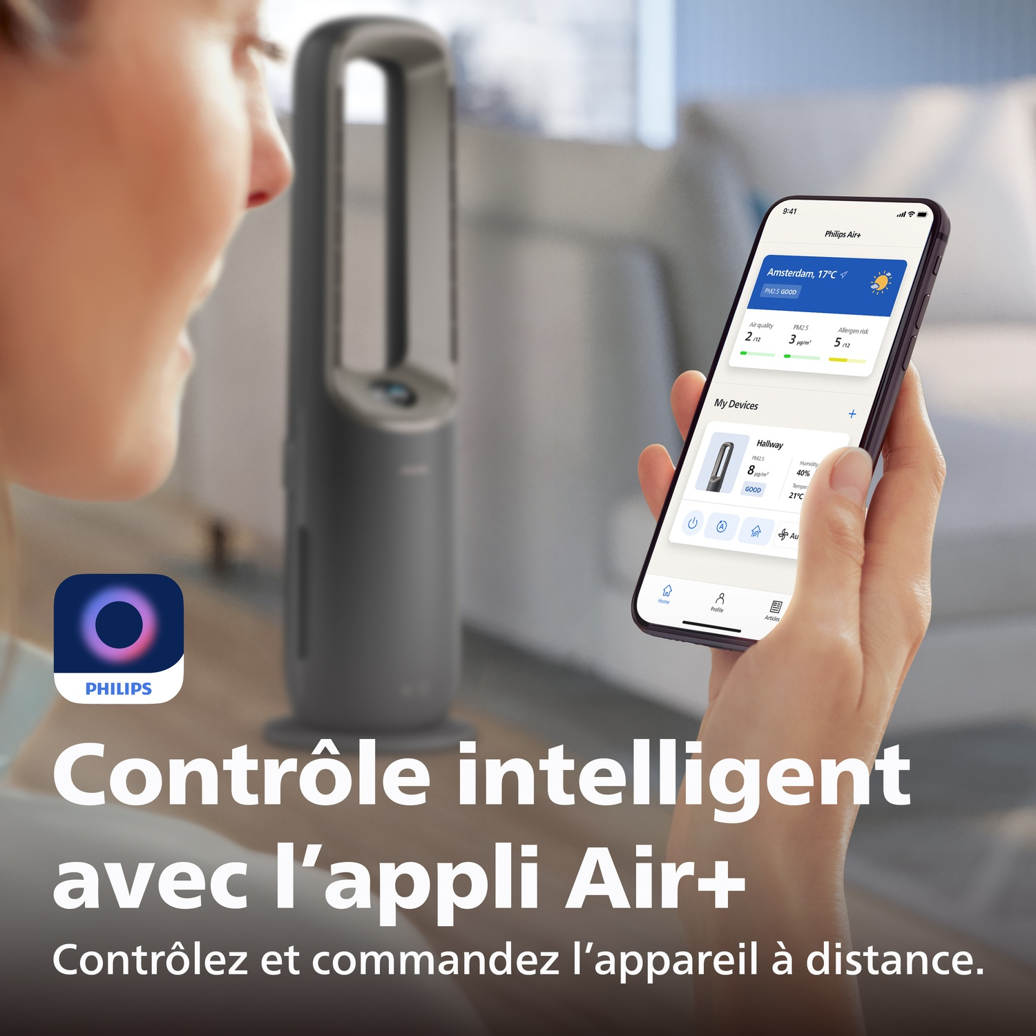 Une personne tient un smartphone avec l'application Philips Air+. Un purificateur d'air est en arrière-plan.