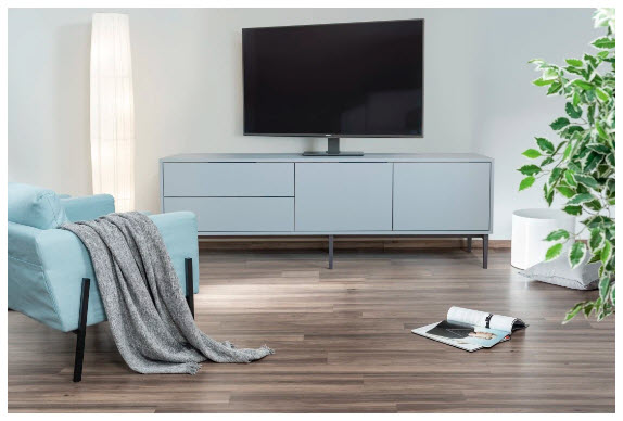 Jasnoniebieska sofa z kocem, szafka RTV, telewizor i roślina.