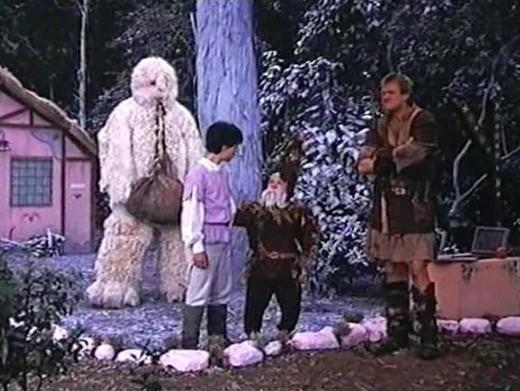 Ein großer weißer Yeti steht neben einem Jungen. Ein Zwerg und ein Mann in Lederkleidung sind auch da.