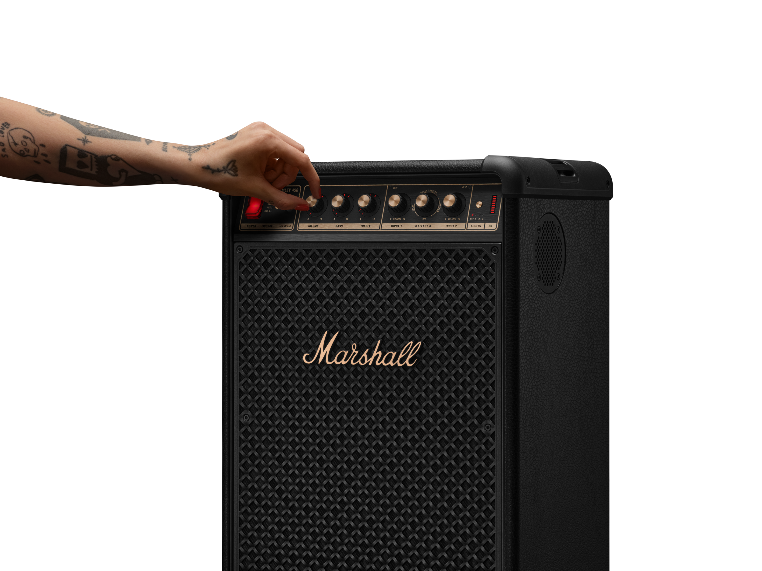 Dövmeli bir el, altın logolu siyah bir Marshall gitar amfisinde bir düğmeyi ayarlıyor.