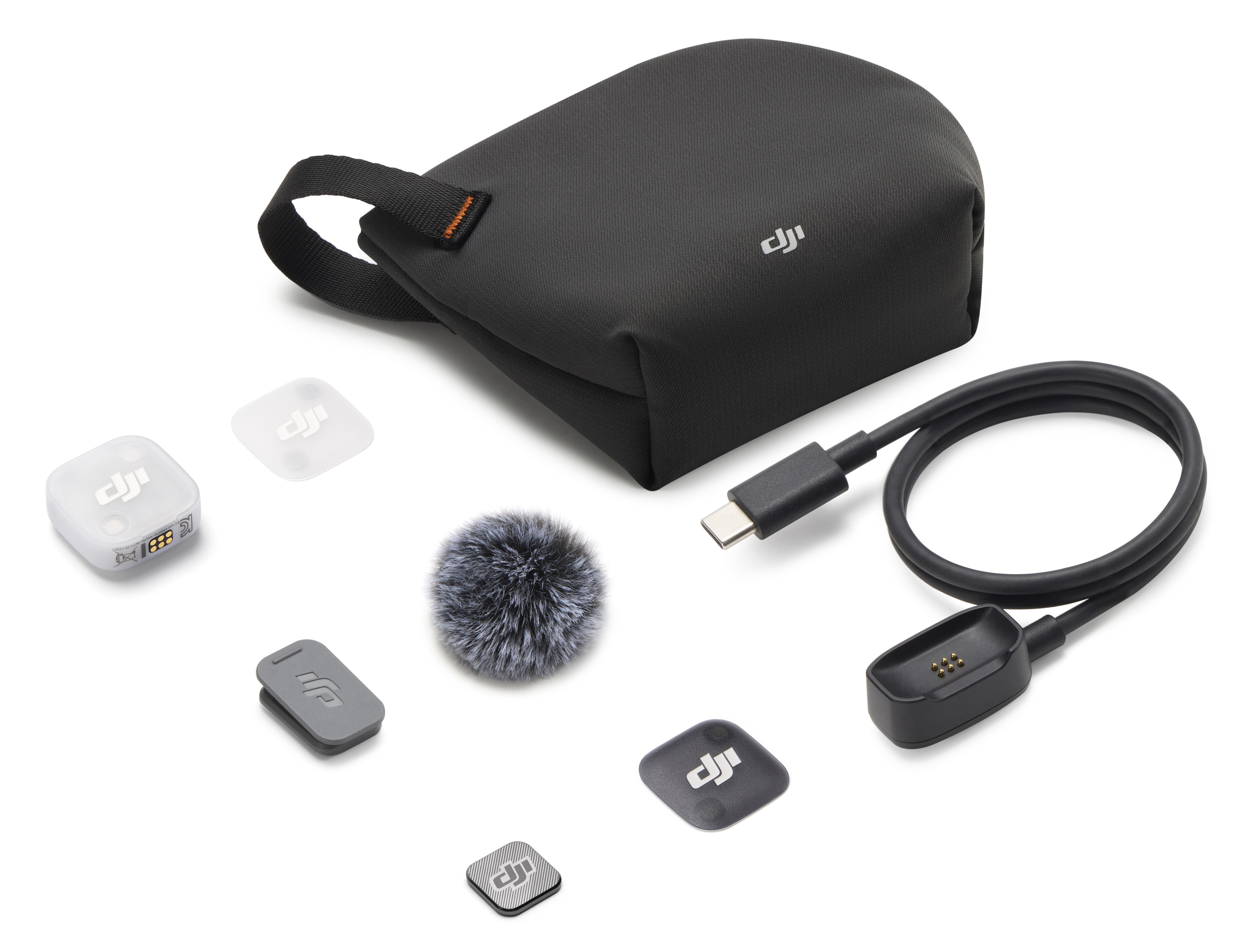 Akcesoria DJI: Czarna torba, mikrofon, kabel, stacja ładująca, białe i szare drobne części.