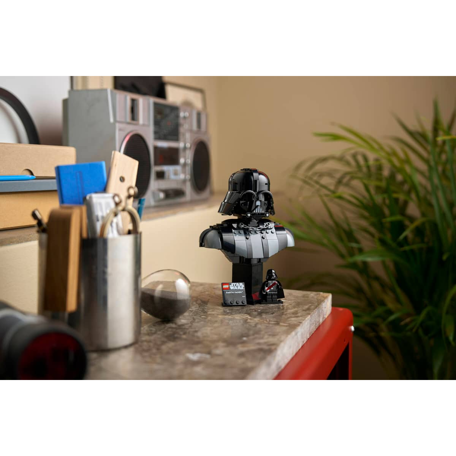 Darth Vader Lego bust with a small minifigure companion on a marble table.