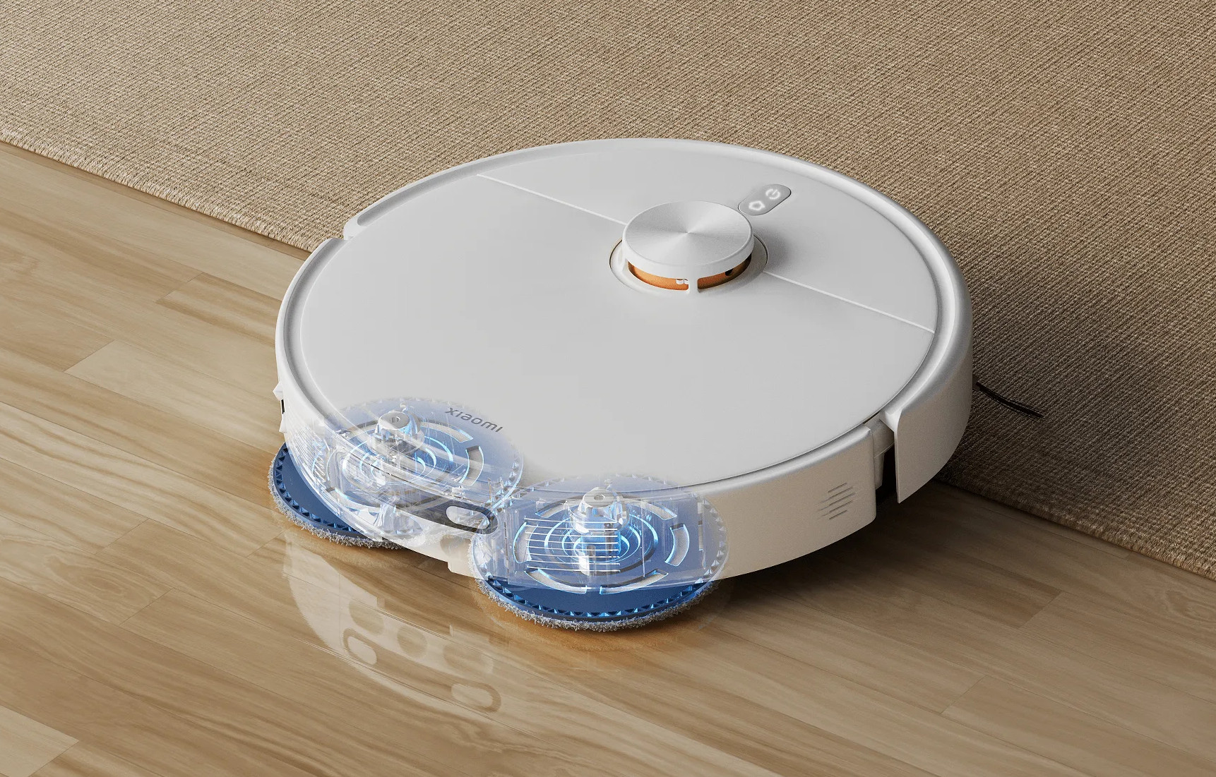 Biały robot sprzątający Xiaomi z obrotowymi niebieskimi szczotkami na drewnianej podłodze obok dywanu.
