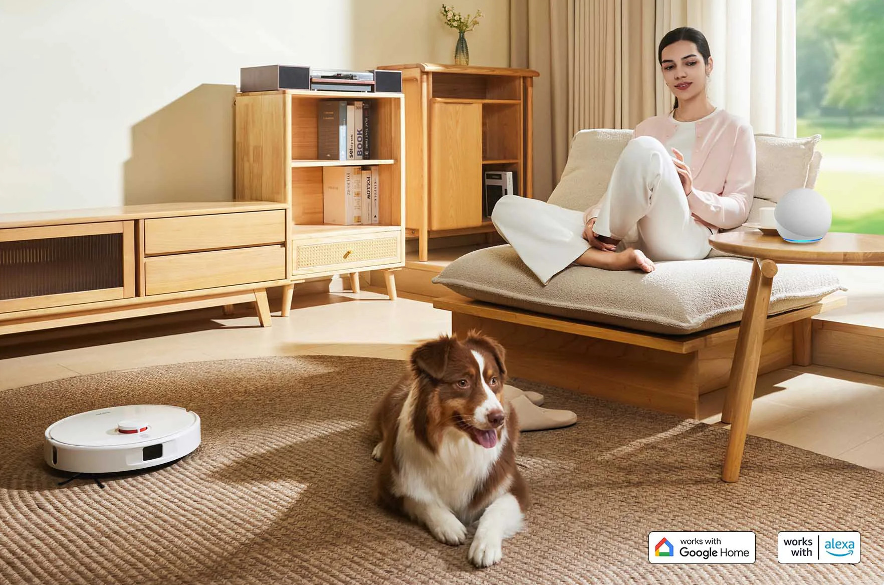 Kobieta relaksuje się na krześle, podczas gdy pies i robot sprzątający odpoczywają na dywanie.