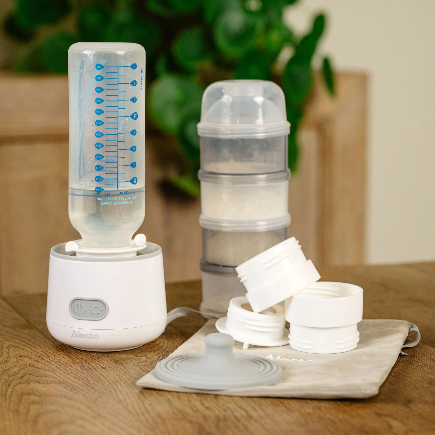 Scaldabiberon Alecto con biberon, dispenser per latte in polvere e accessori.