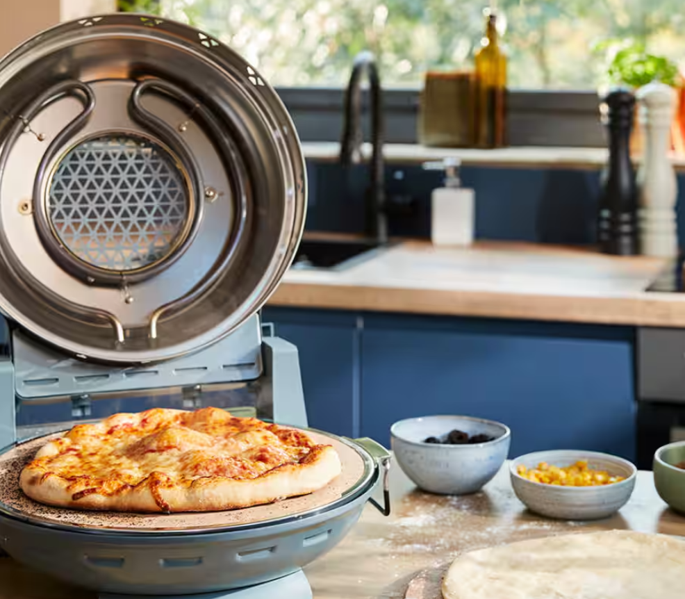 Una pizza appena sfornata in un forno per pizza aperto con formaggio fuso.