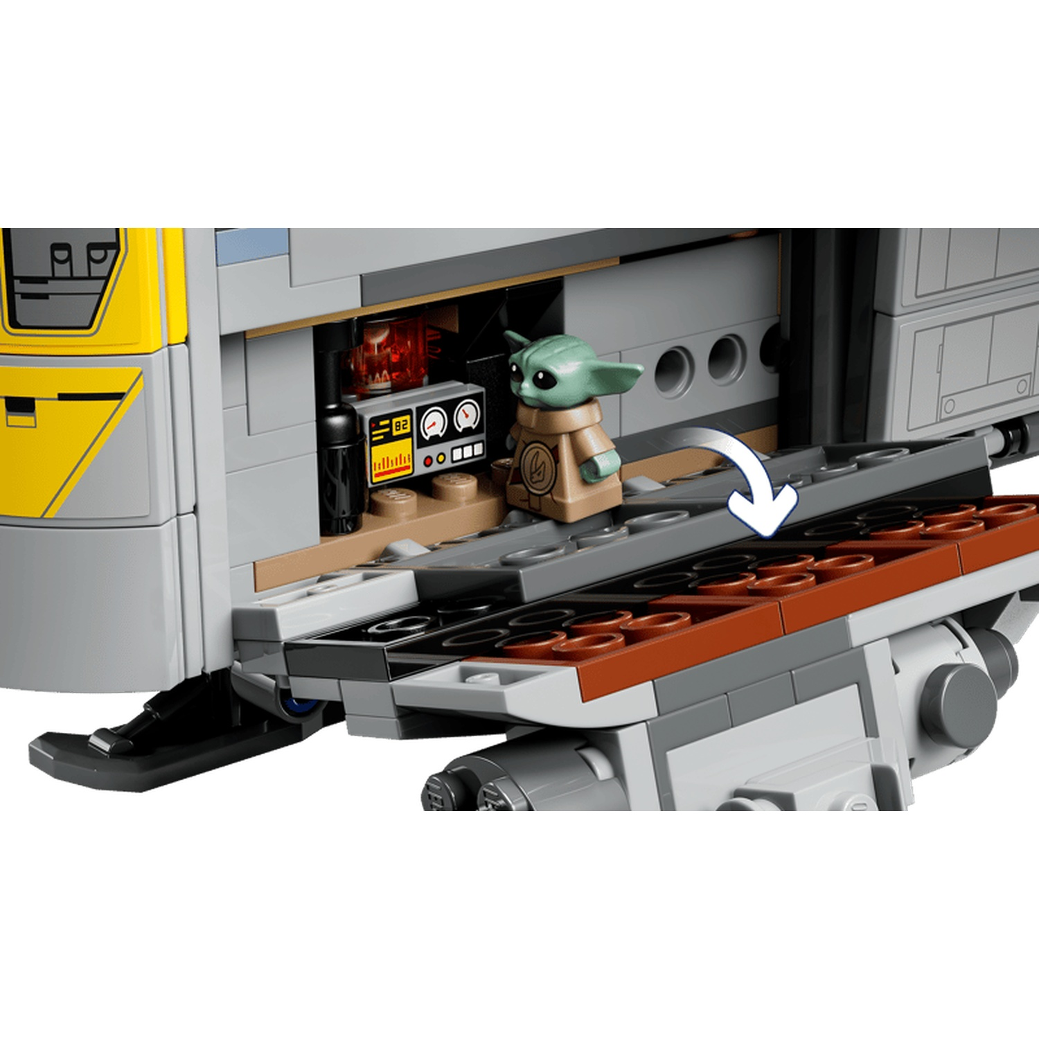 Baby Yoda stands by a yellow and gray LEGO ship with control panels.