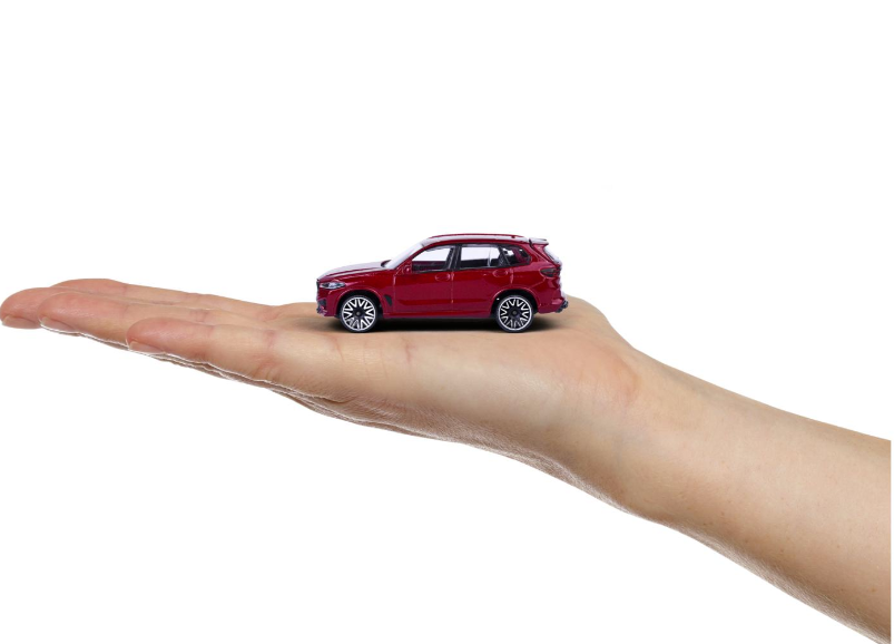 Ein rotes Spielzeugauto liegt auf einer geöffneten Handfläche, weißer Hintergrund.