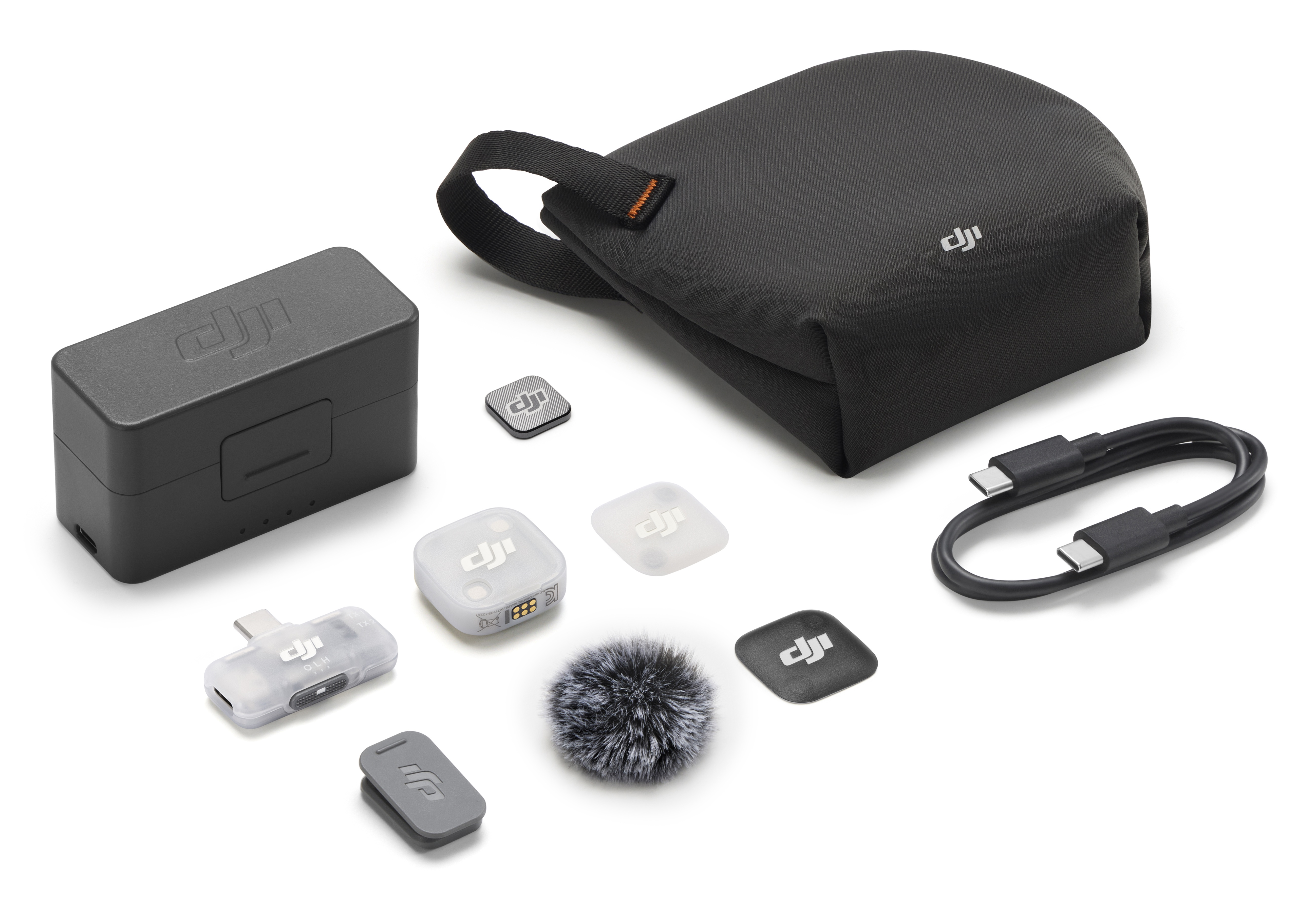 Akcesoria do mikrofonu DJI: etui ładujące, nadajnik, odbiornik, kabel i osłona przeciwwietrzna.
