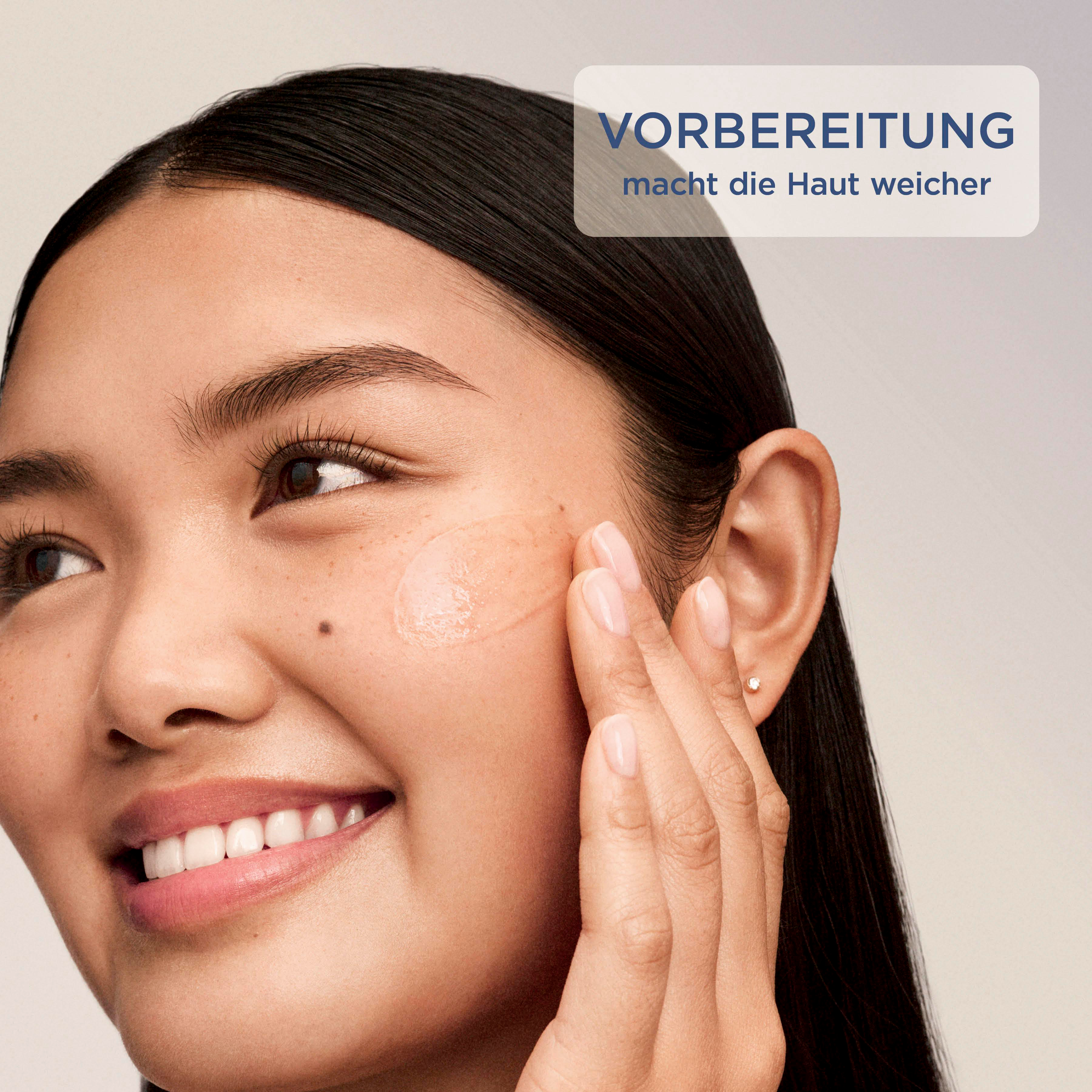 Eine Frau trägt eine Feuchtigkeitscreme auf ihr Gesicht auf.