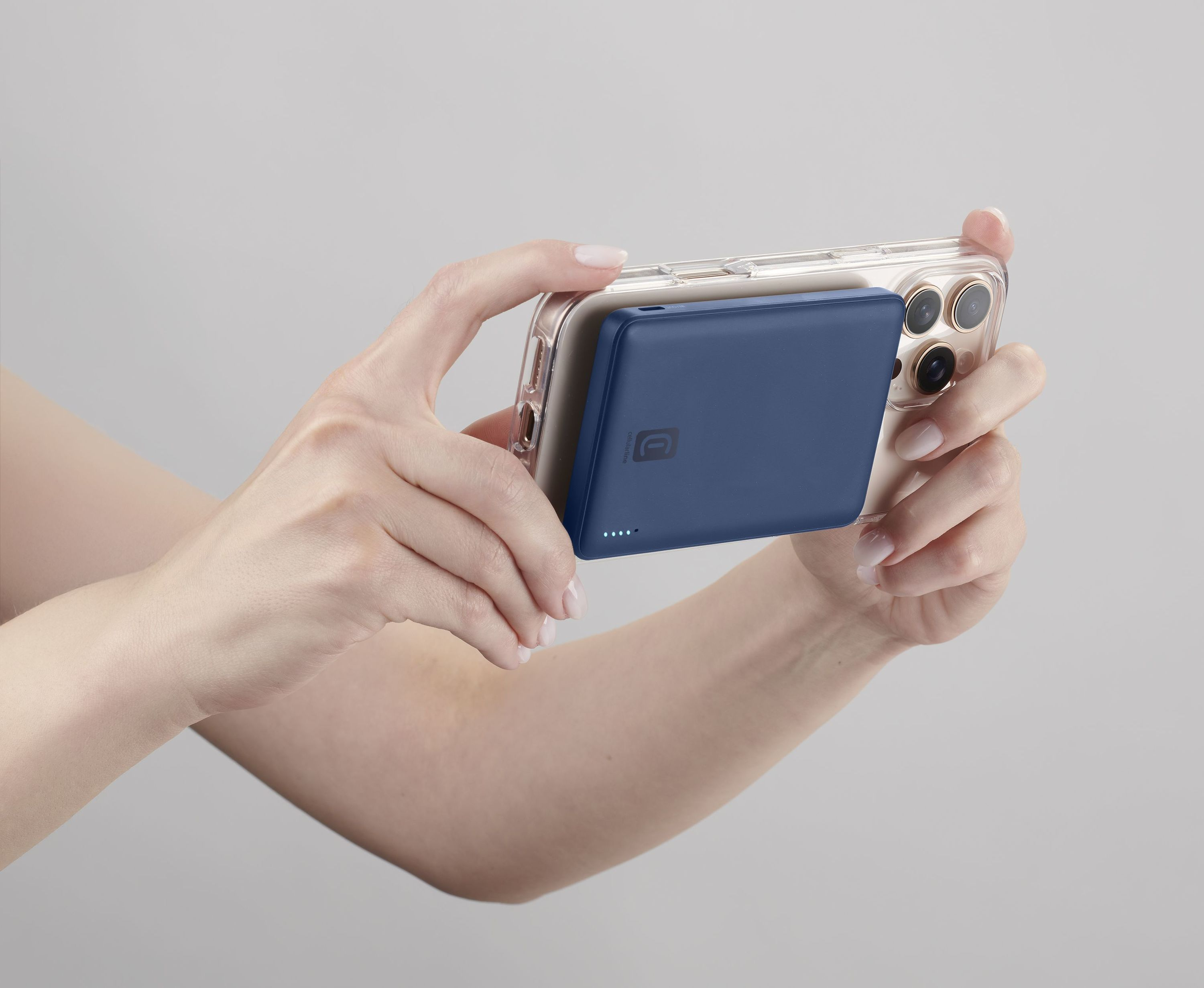 Bir kişi, yatay modda mavi bir powerbank'lı akıllı telefon tutuyor.