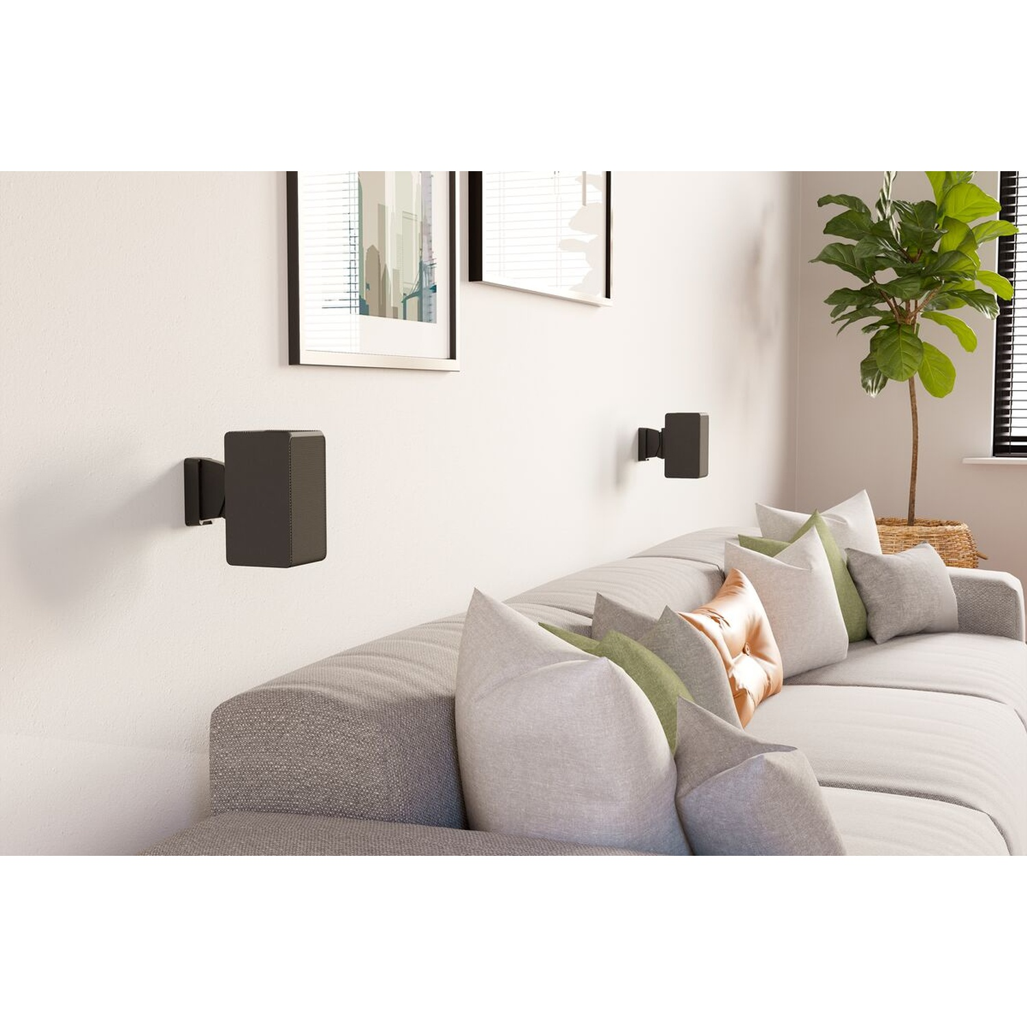 Haut-parleurs noirs fixés au mur au-dessus d'un canapé avec coussins et plante.