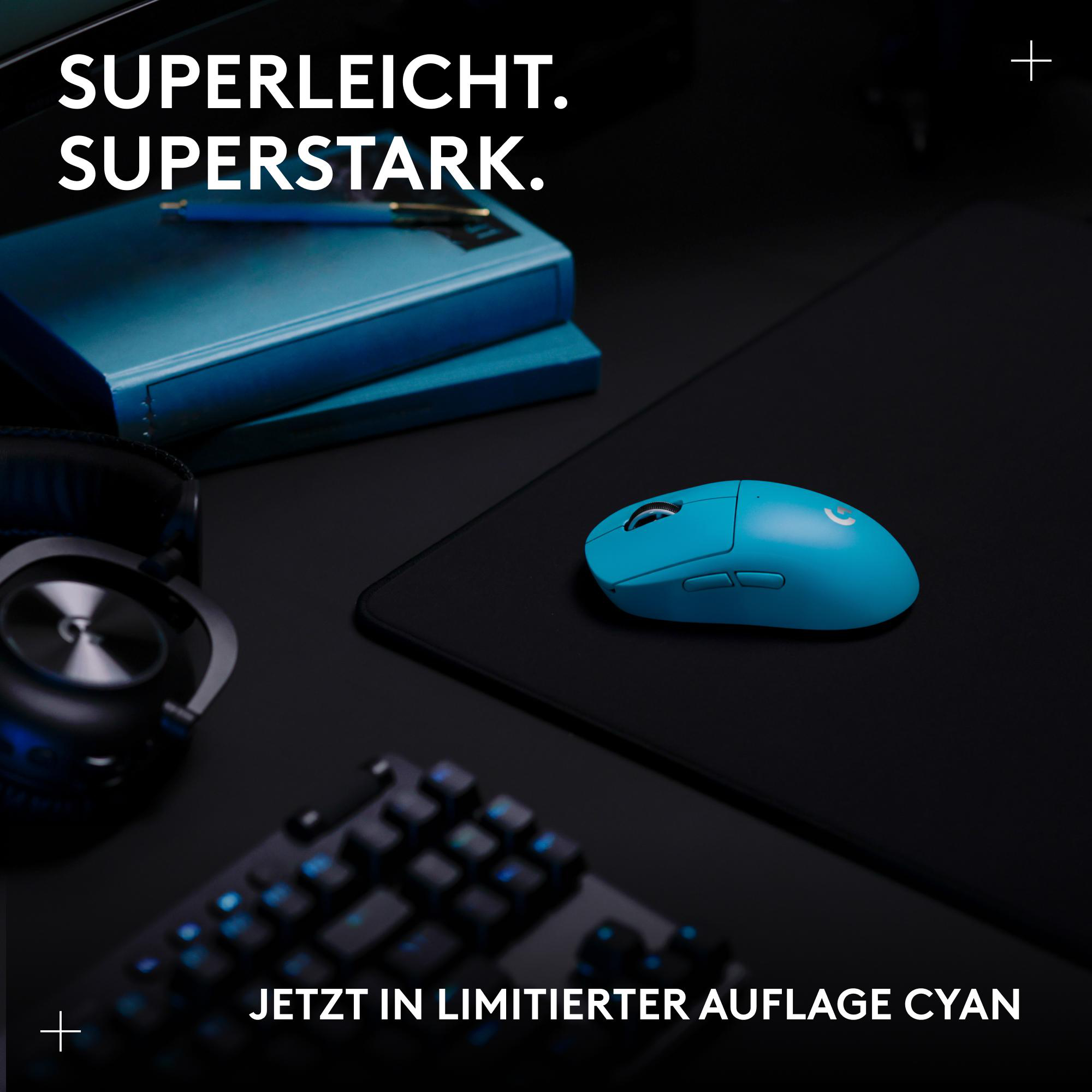 Blaue Maus, Tastatur, Kopfhörer und Notizbuch auf dunklem Hintergrund.