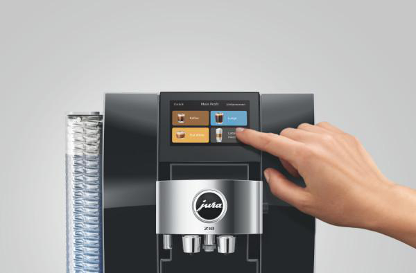 Eine Hand berührt den Bildschirm einer Kaffeemaschine mit verschiedenen Getränkeoptionen.